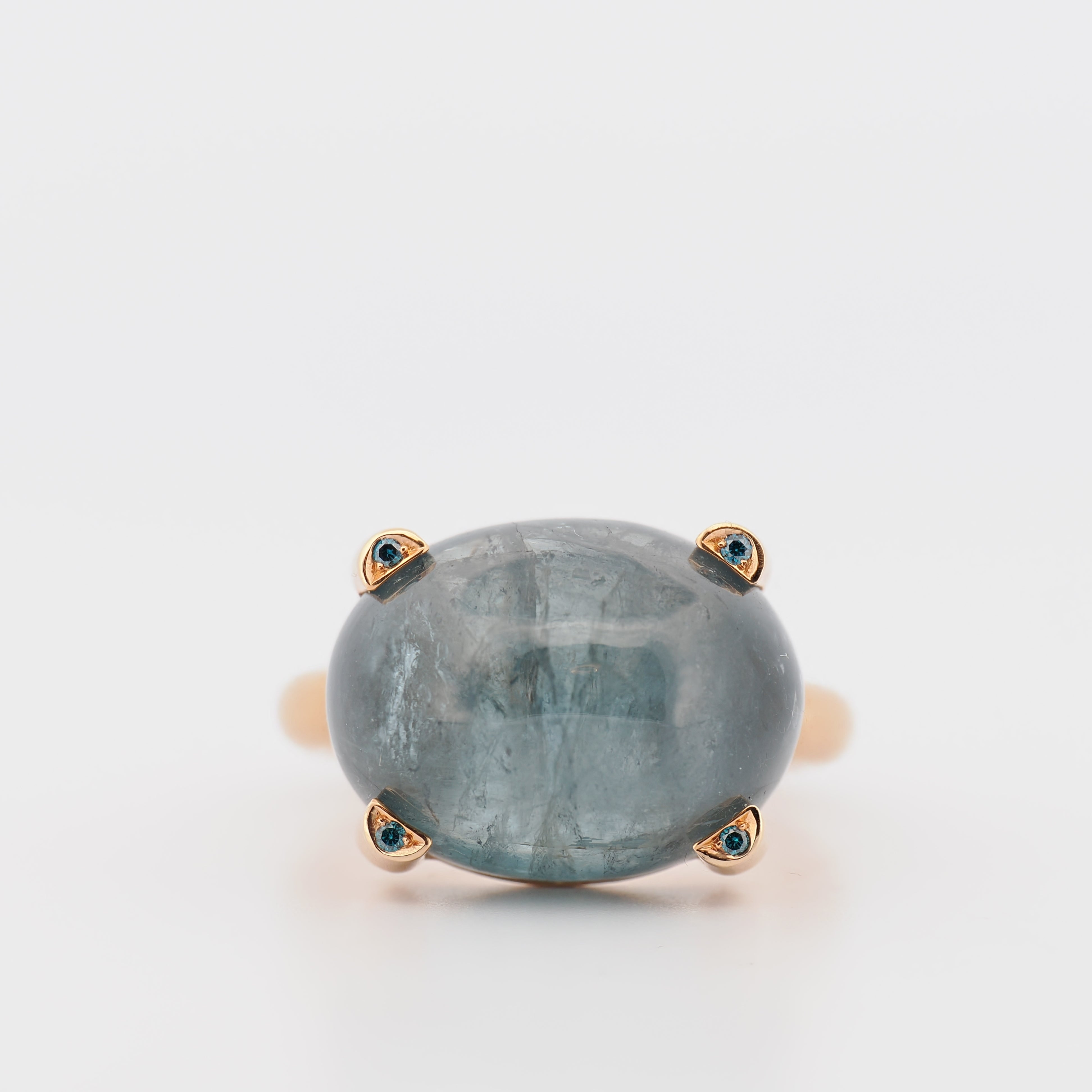 Spliedt Ring Rosegold mit Turmalin, Vorderansicht eines ovalen Turmalin-Cabochons in Roségoldfassung mit kleinen blauen Ak…