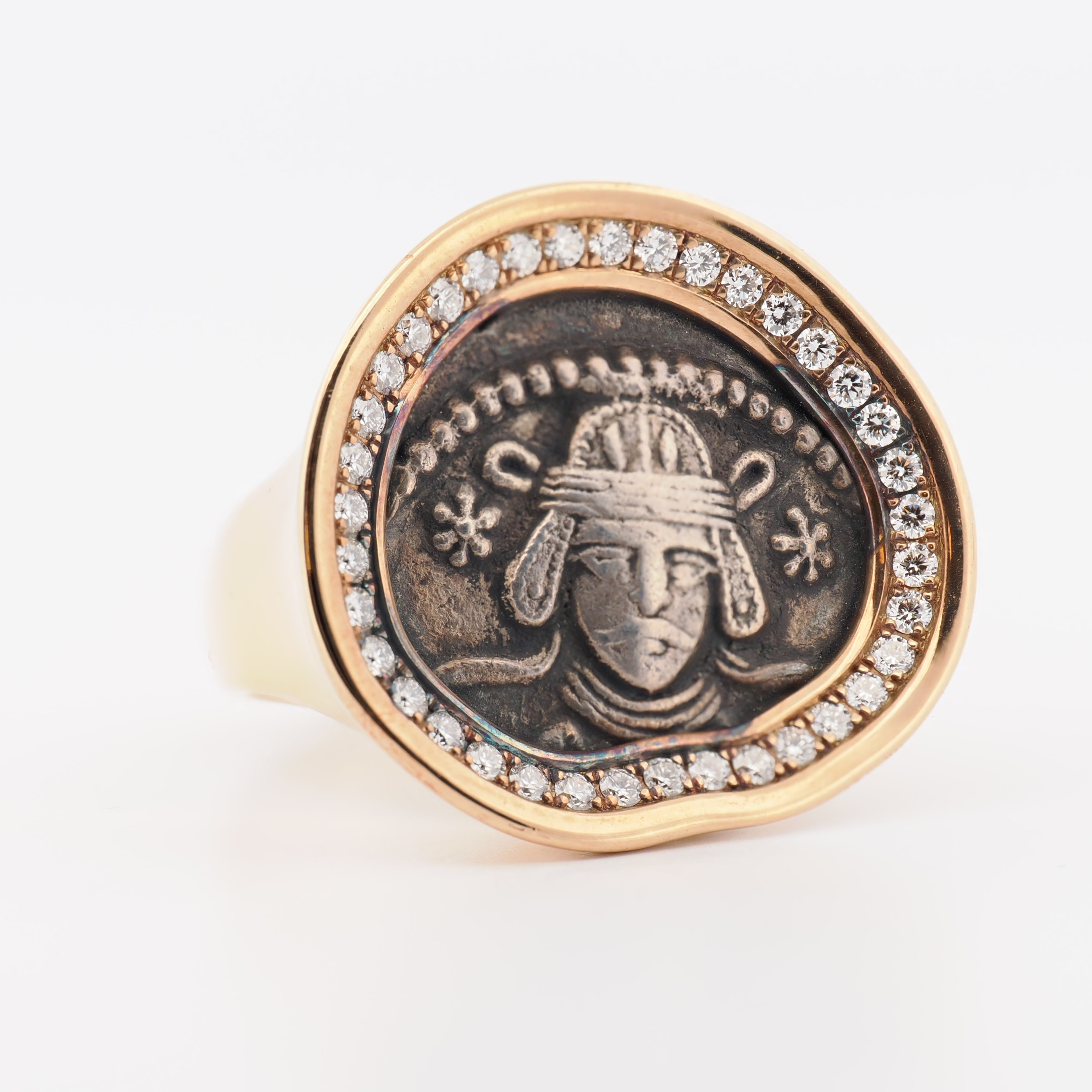 Twenty Ten Ring in Roségold mit Münze und Brillanten, Nahaufnahme auf weißem Hintergrund