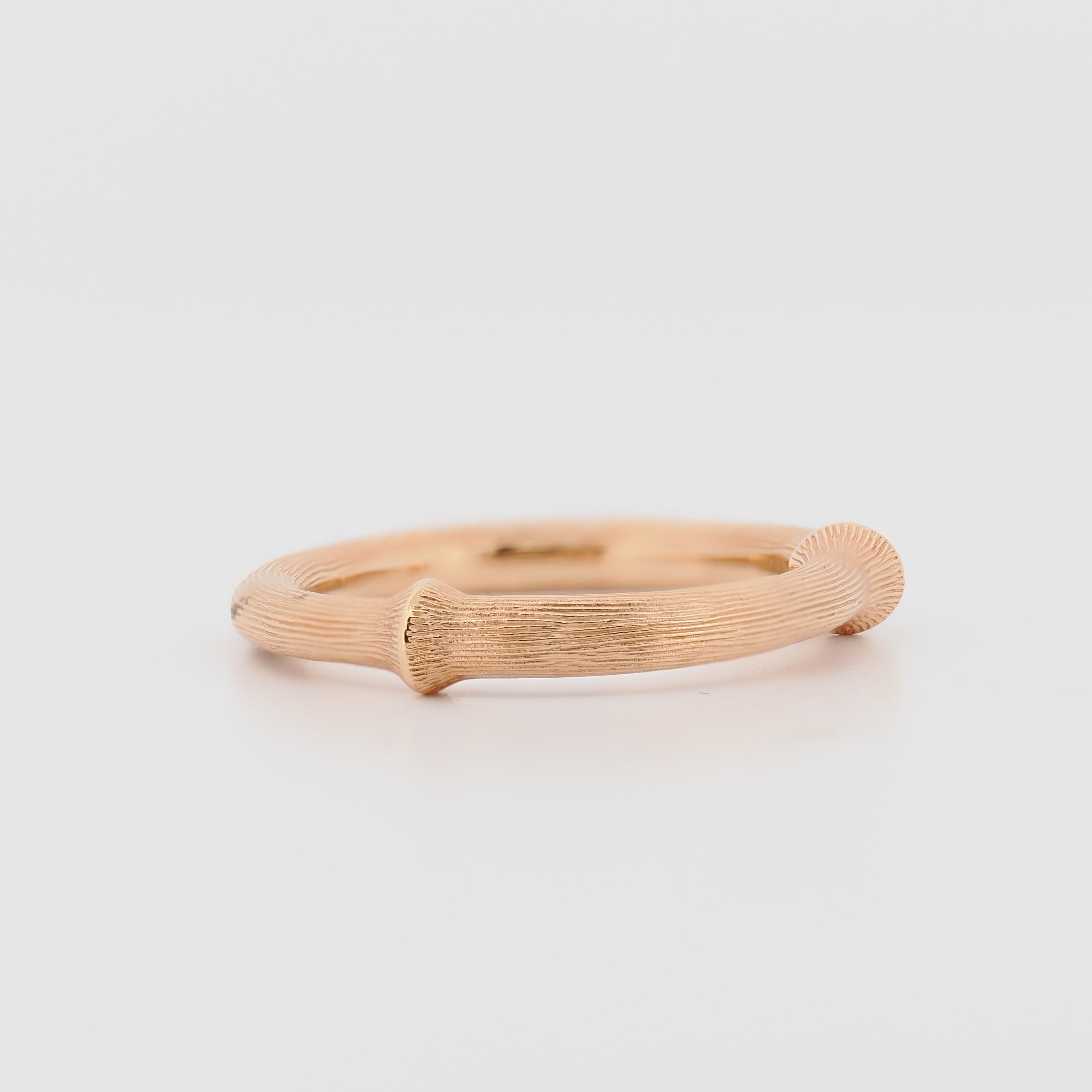 Ole Lynggaard Nature Ring IV aus Roségold mit Rillenmuster auf weißem Hintergrund