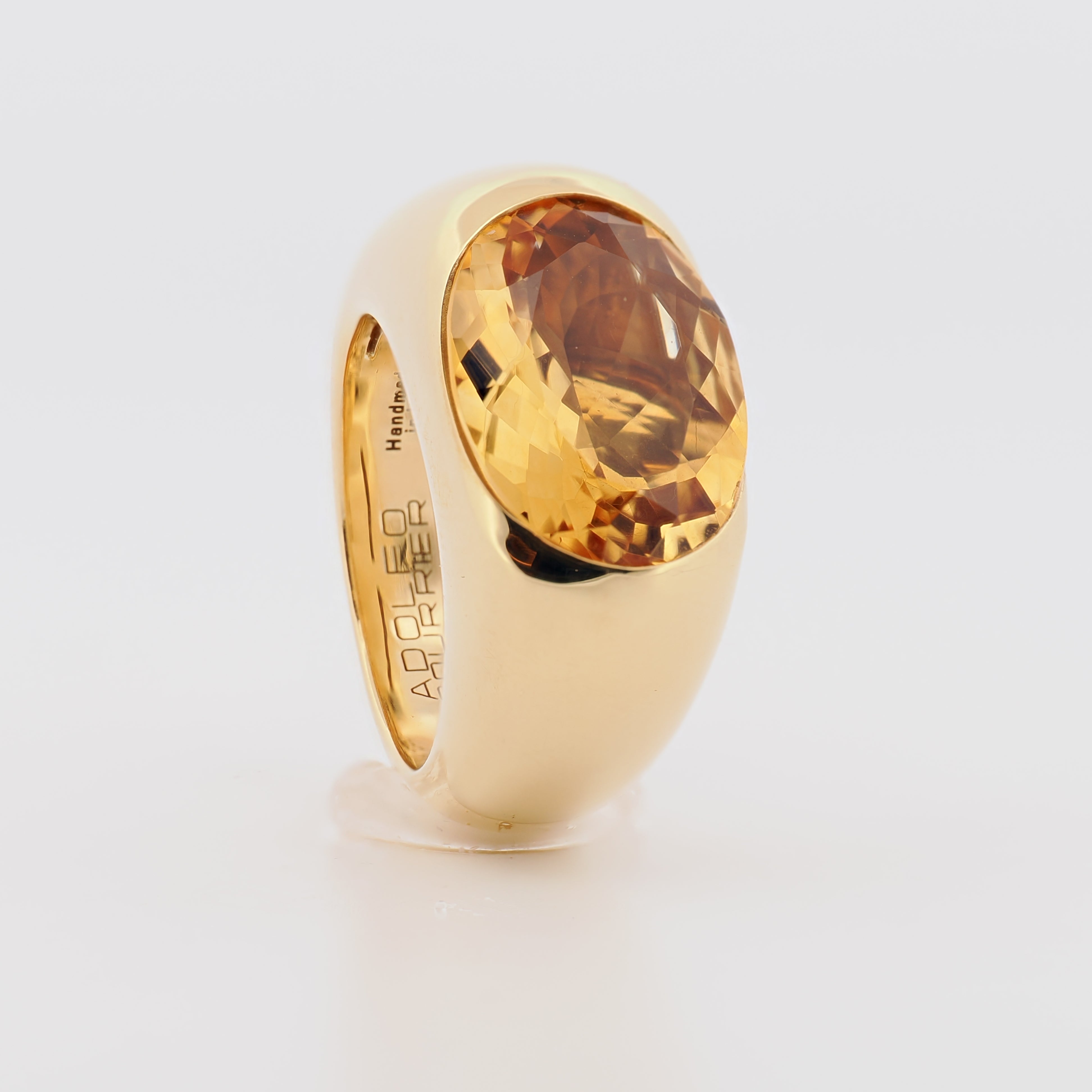 Adolfo Courrier Ring aus Gelbgold mit einem facettierten Citrin auf hellem Hintergrund