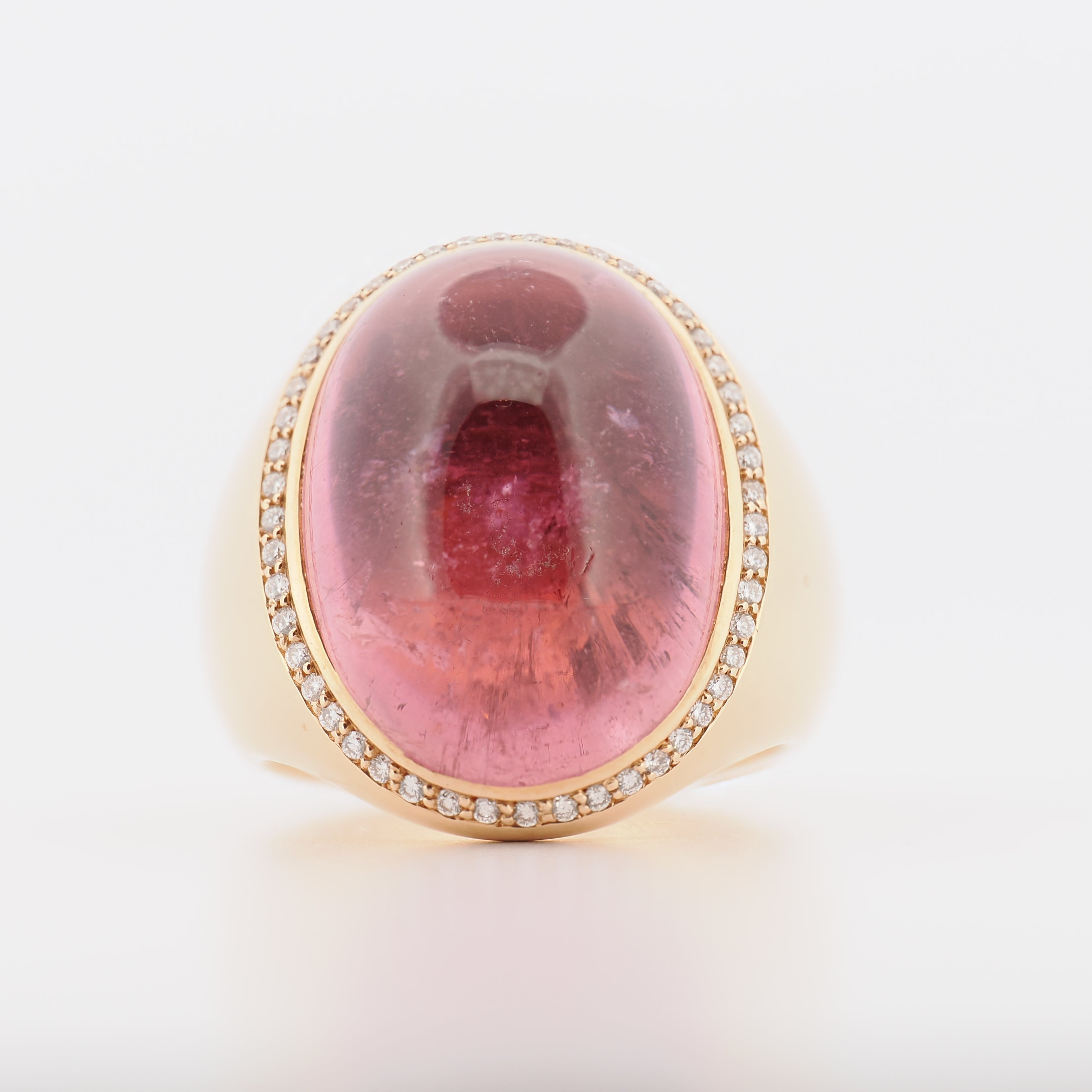 Ein Ring aus 18 Karat Roségold mit großem, rosenrotem Turmalin-Cabochon, umrandet von kleinen Diamanten