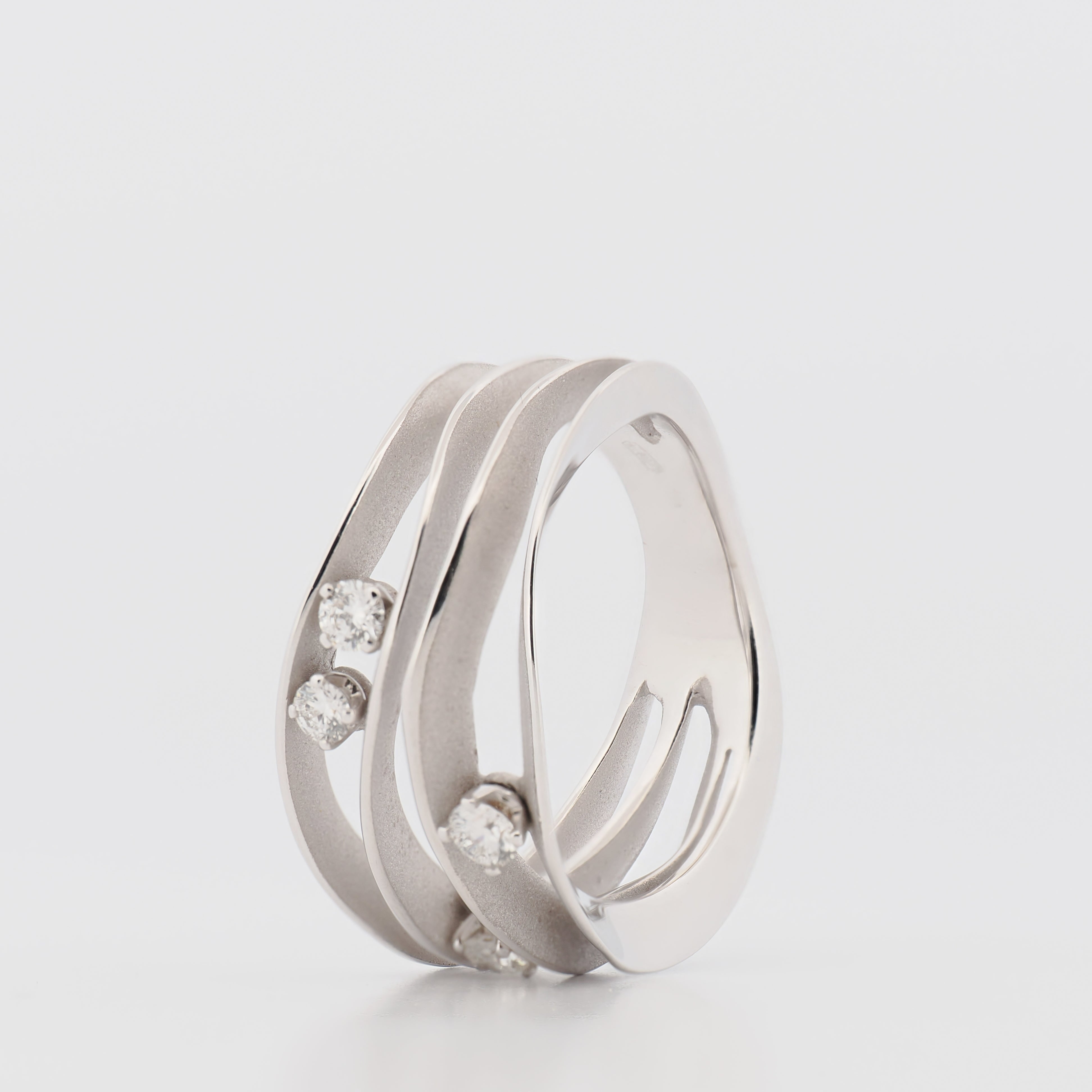 Annamaria Camilli Ring Dune aus 18k Weißgold mit drei Diamanten vor hellem Hintergrund