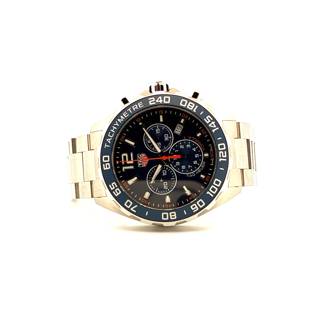 Tag Heuer Formula 1 Chronograph Quarz 43mm mit blauem Zifferblatt und blauem Ring, Stahlarmband auf weissem Hintergrund