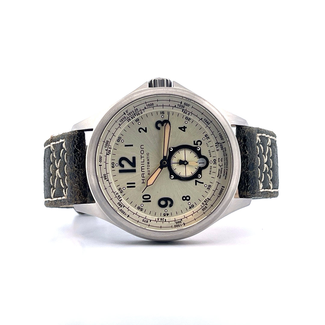Hamilton Khaki Aviation Qne / 2025, Vorderansicht mit Zifferblatt, Krone und Armband vor weißem Hintergrund