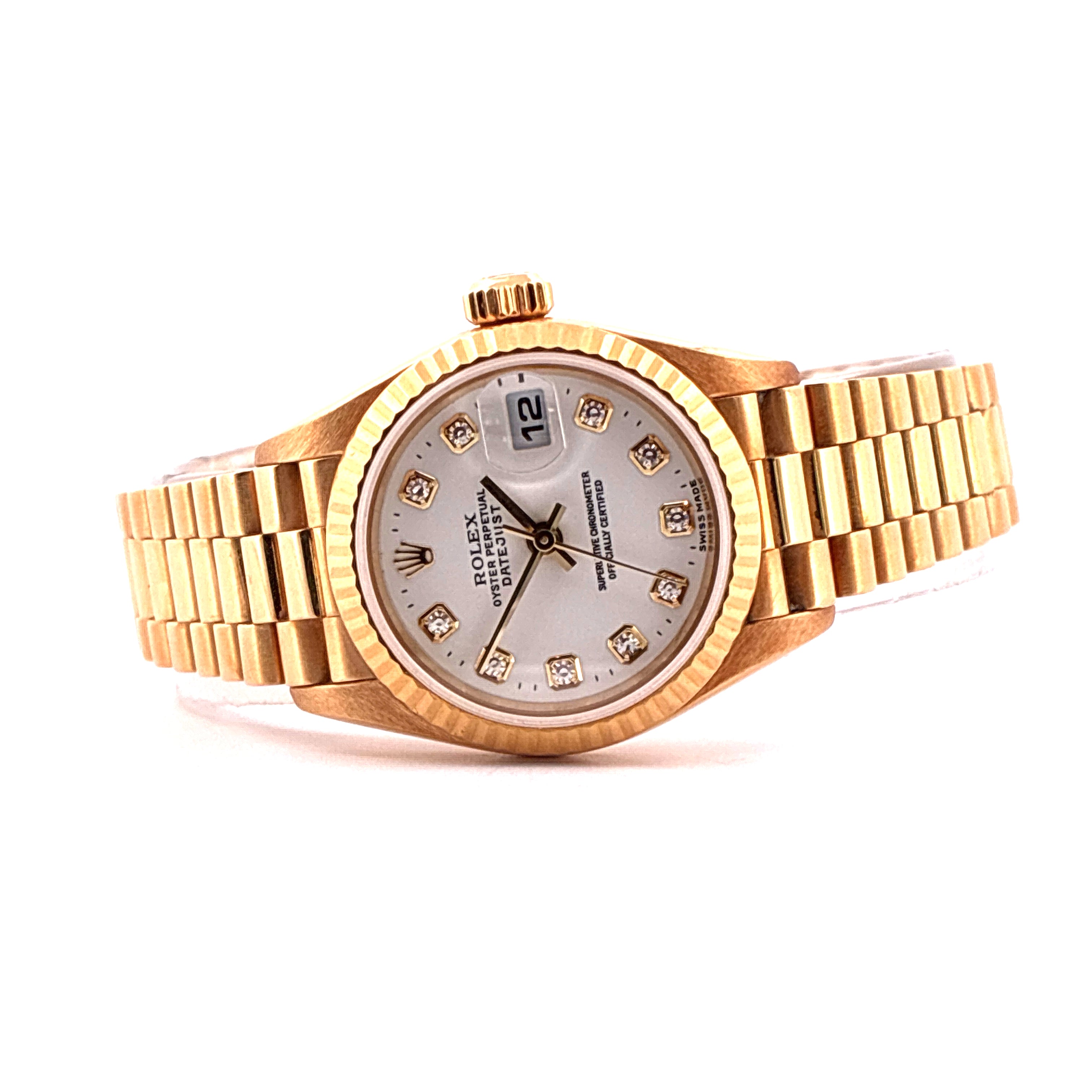 Eine goldene Rolex Lady-Datejust Uhr mit 12 Diamanten auf dem Zifferblatt und einem Datumsfenster auf weißem Hintergrund