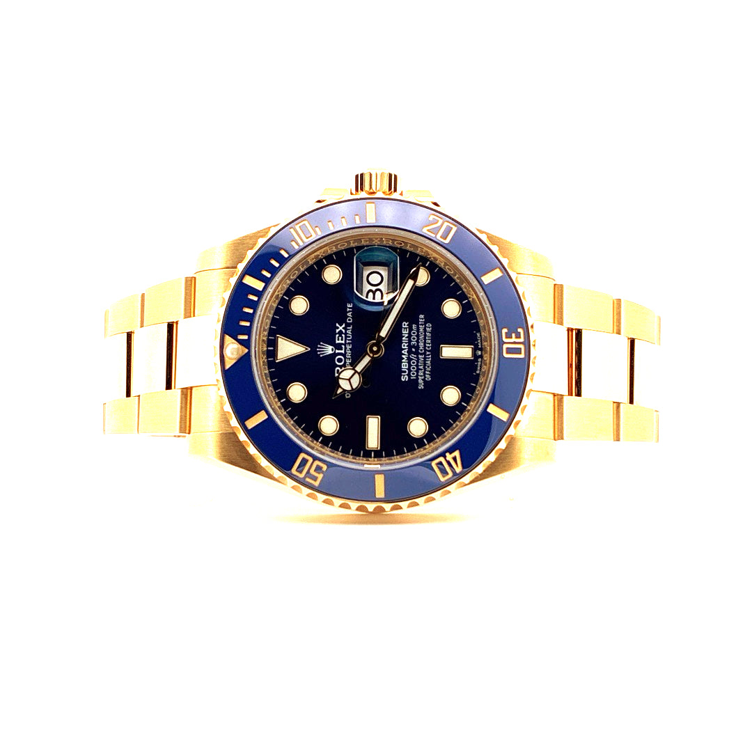 Eine gelbgoldene Rolex Submariner Date 126618LB mit blauem Zifferblatt und Armband vor weißem Hintergrund
