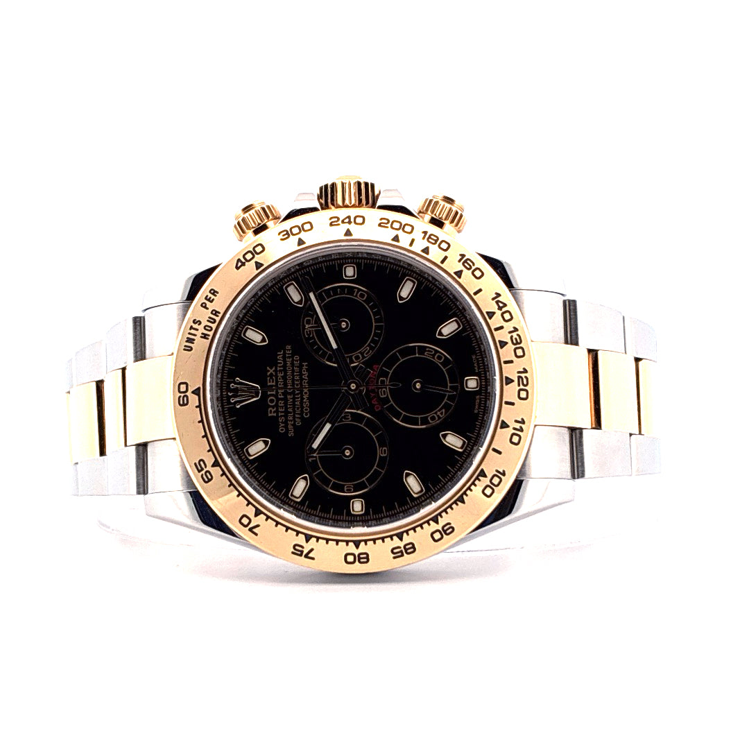 Rolex Daytona Bicolor mit schwarzem Zifferblatt, goldener Luenette und bicolor Armband auf weissem Hintergrund