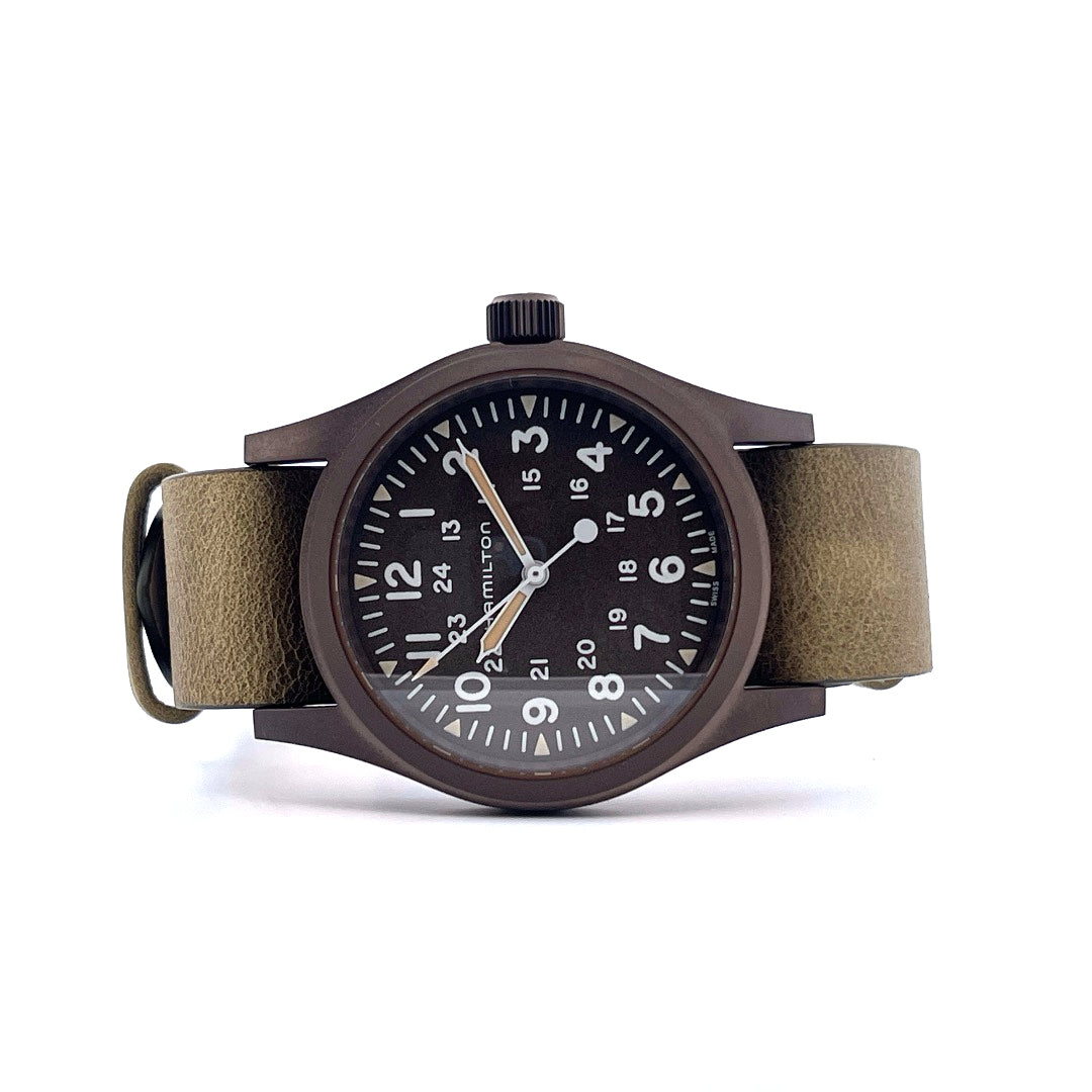 Hamilton Khaki Field Mechanical / box / certificate / like new / unworn / 2025, Vorderansicht mit Zifferblatt, Krone und Armband vor weißem Hintergrund