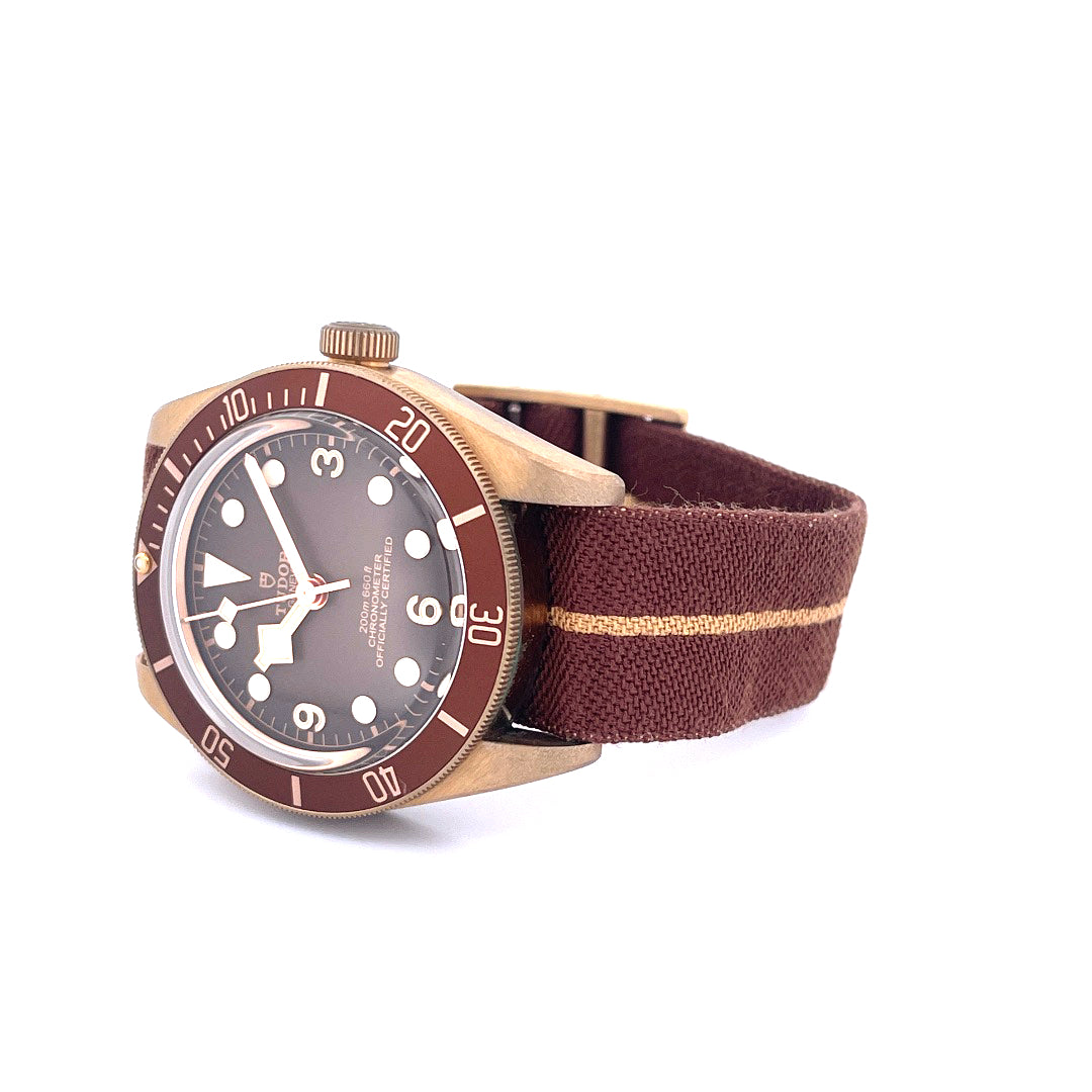 Tudor Black Bay Fifty-eight Boutique Edition in Bronze mit braunem Stoffarmband auf weißem Hintergrund, Nahaufnahme von re…