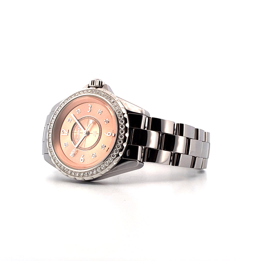 Chanel J12 33mm powder pink mit Diamantlünette und silbernem Armband im Detailaufnahme
