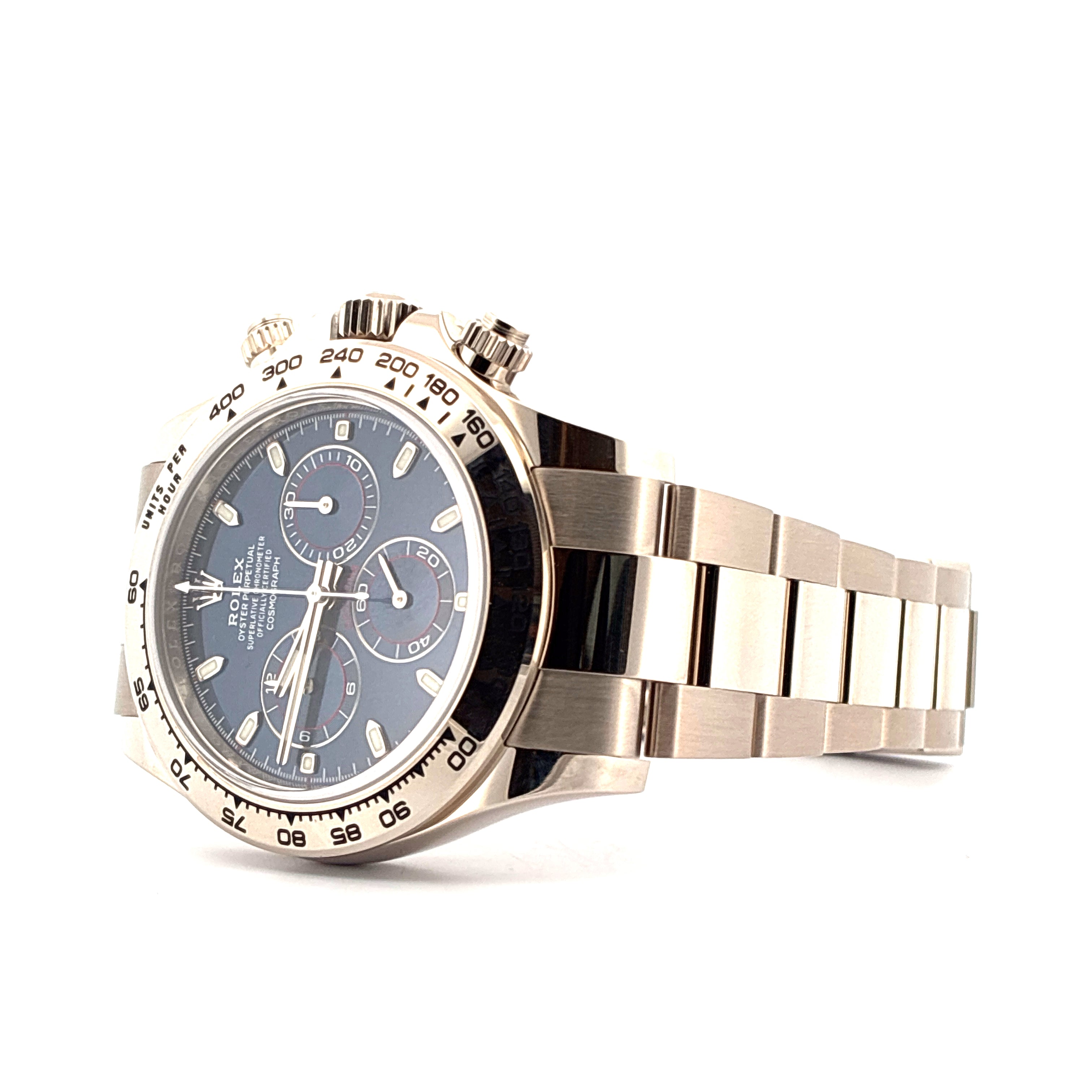 Rolex Daytona in Weißgold, von der Seite aufgenommen, mit blauem Zifferblatt und drei Chronographen-Anzeigen auf weißem Hintergrund