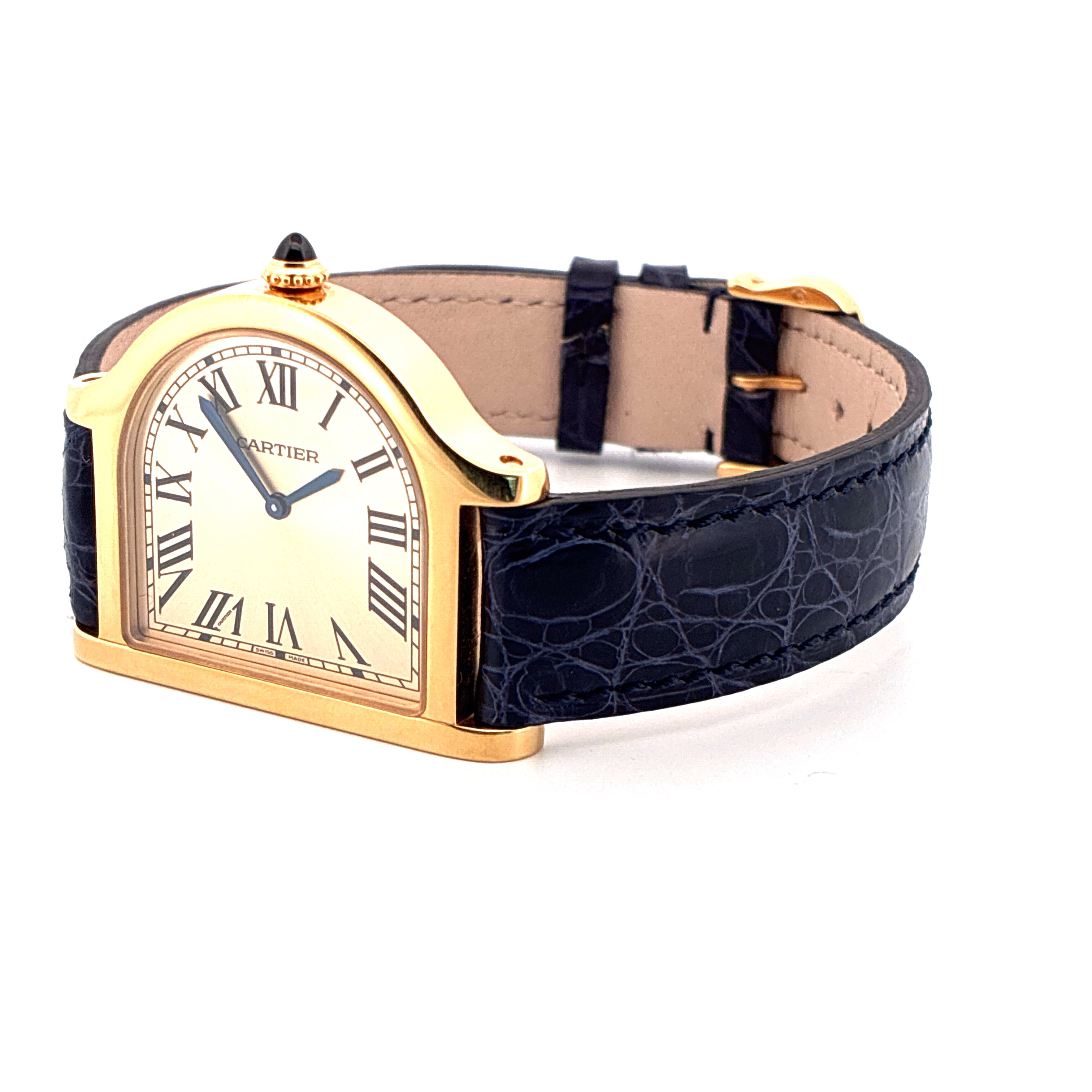 Eine Cartier Cloche De Cartier Uhr aus Gelbgold mit blauem Kroko-Lederband, im halbschrägen Profil auf weißem Hintergrund