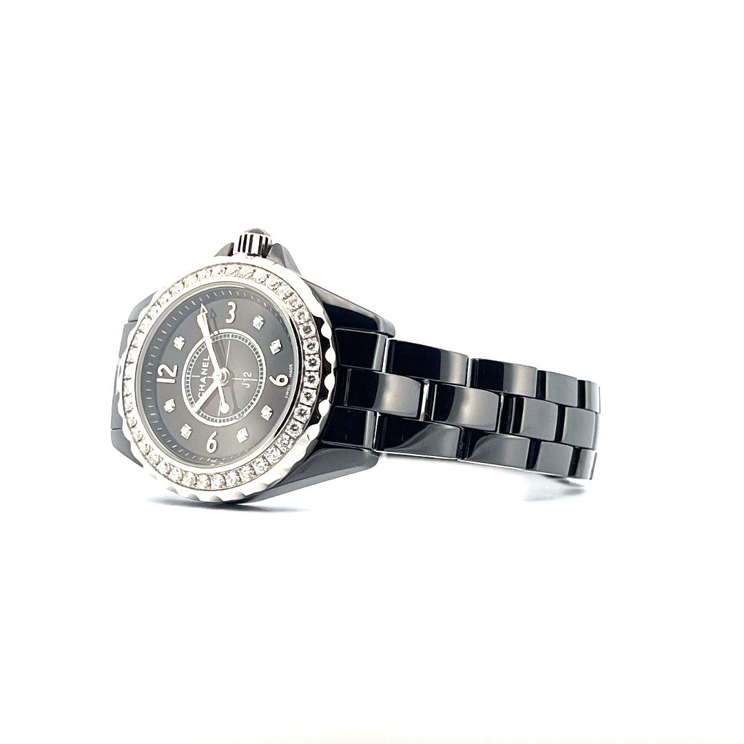 Chanel J12 29mm Quarz Uhr aus Keramik mit Diamantlünette und schwarzem Keramikarmband auf weißem Hintergrund