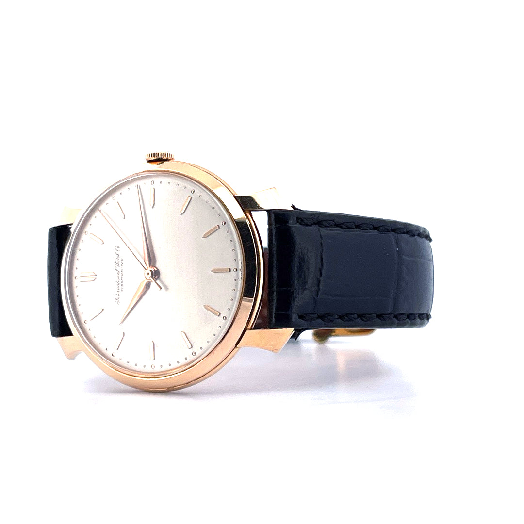 IWC Shark Fin Armbanduhr mit roségoldfarbenem Gehäuse, hellem Zifferblatt und schwarzem Lederarmband auf weissem Hintergrund