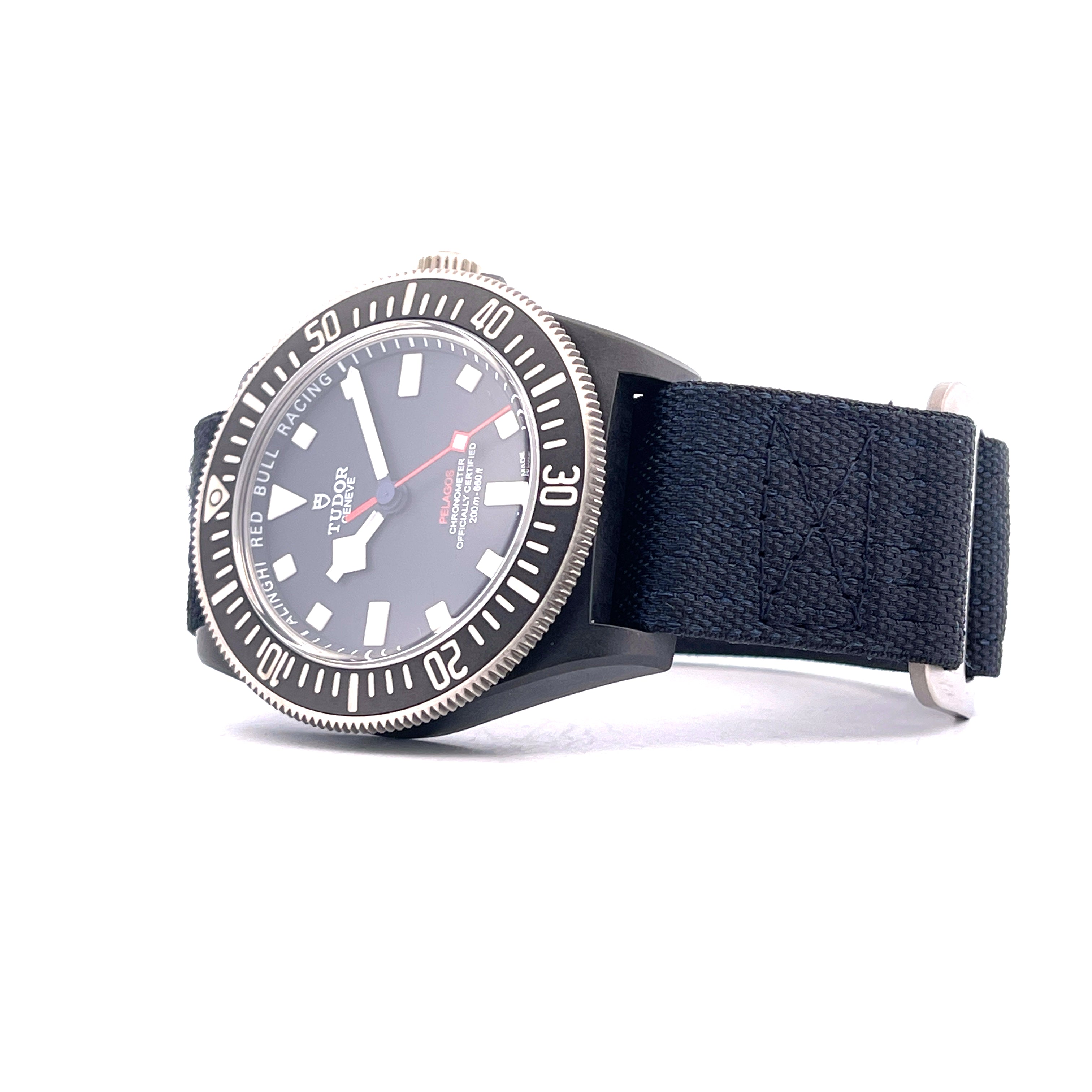 Tudor Alinghi Red Bull Pelagos FXD Uhr in Seitenansicht mit schwarzem Textilarmband auf weißem Hintergrund