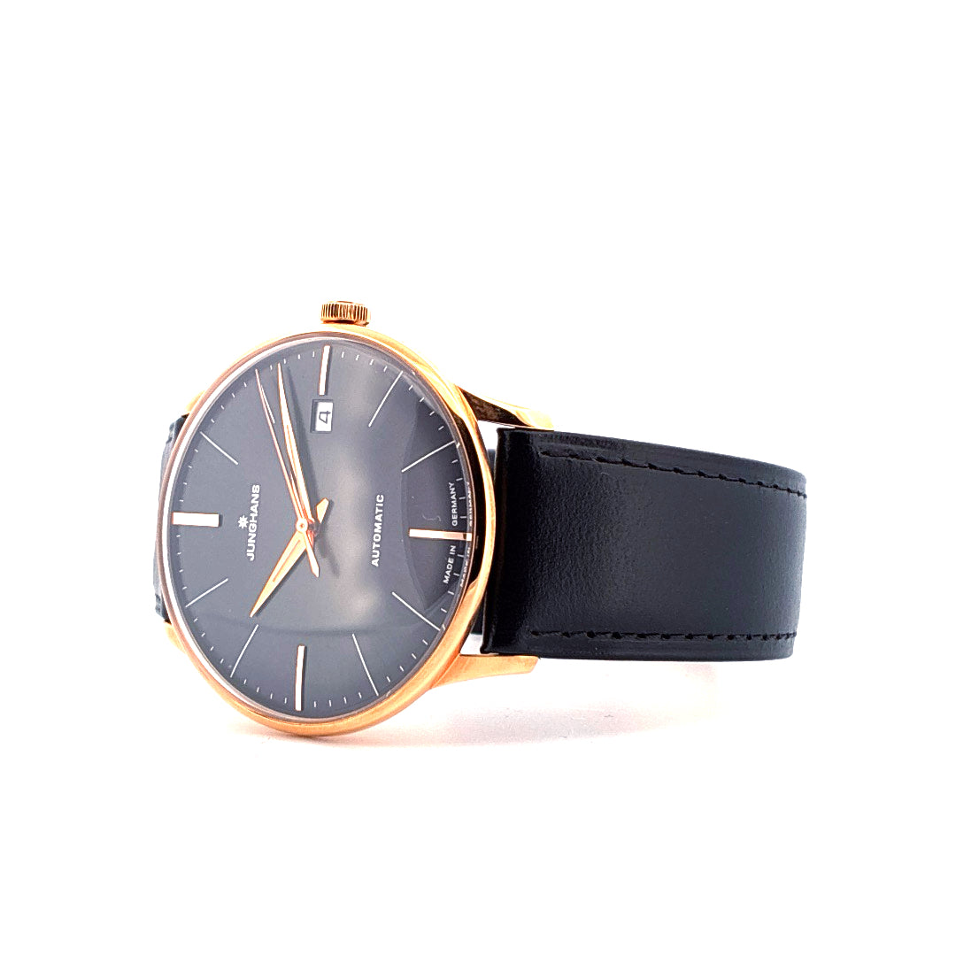 Junghans Meister Damenuhr mit grauem Zifferblatt, roségoldfarbenem Gehäuse und schwarzem Lederarmband vor weißem Hintergrund