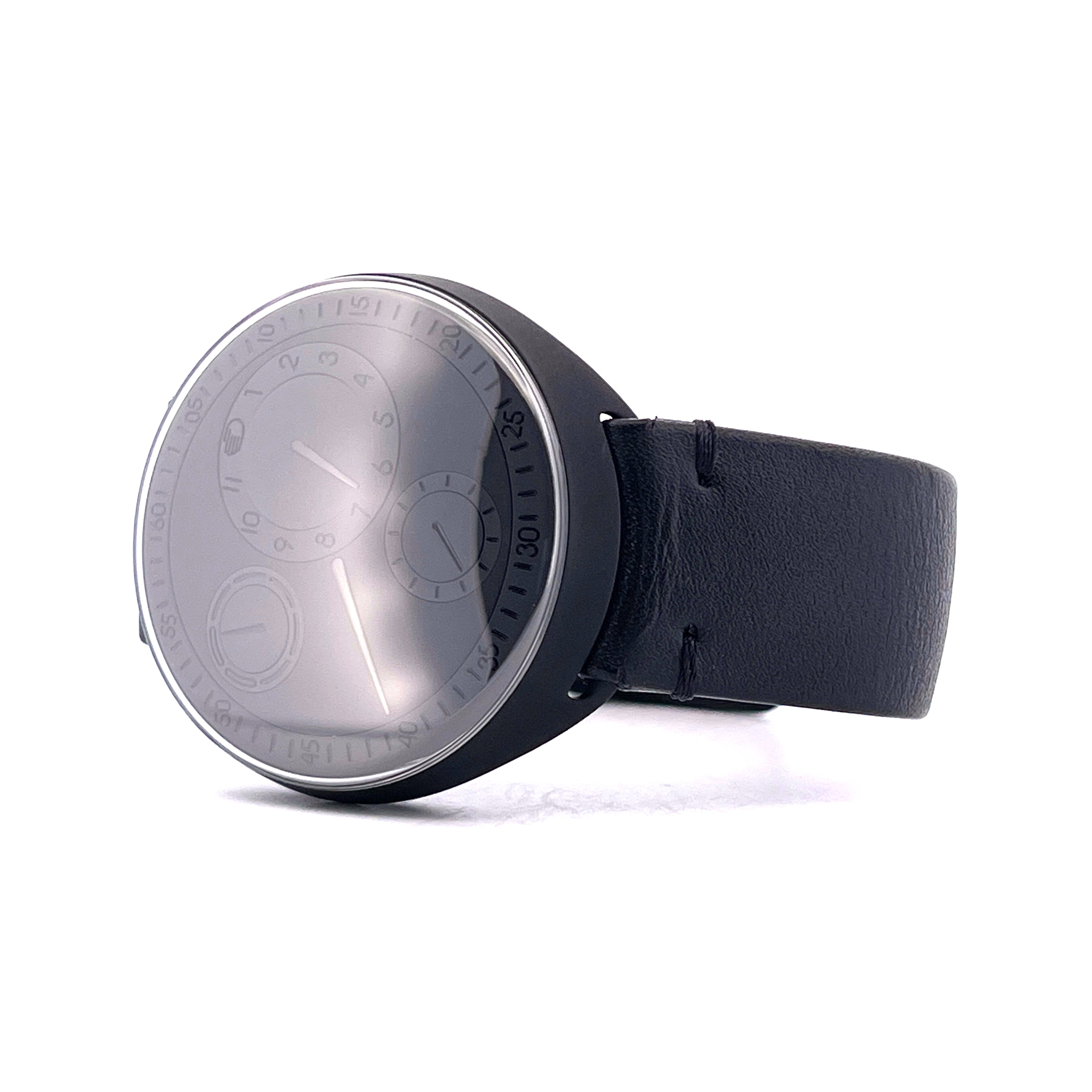 Ressence Type 1 ZZ Chronopassion mit schwarzem Lederarmband und grauem Zifferblatt auf weißem Grund