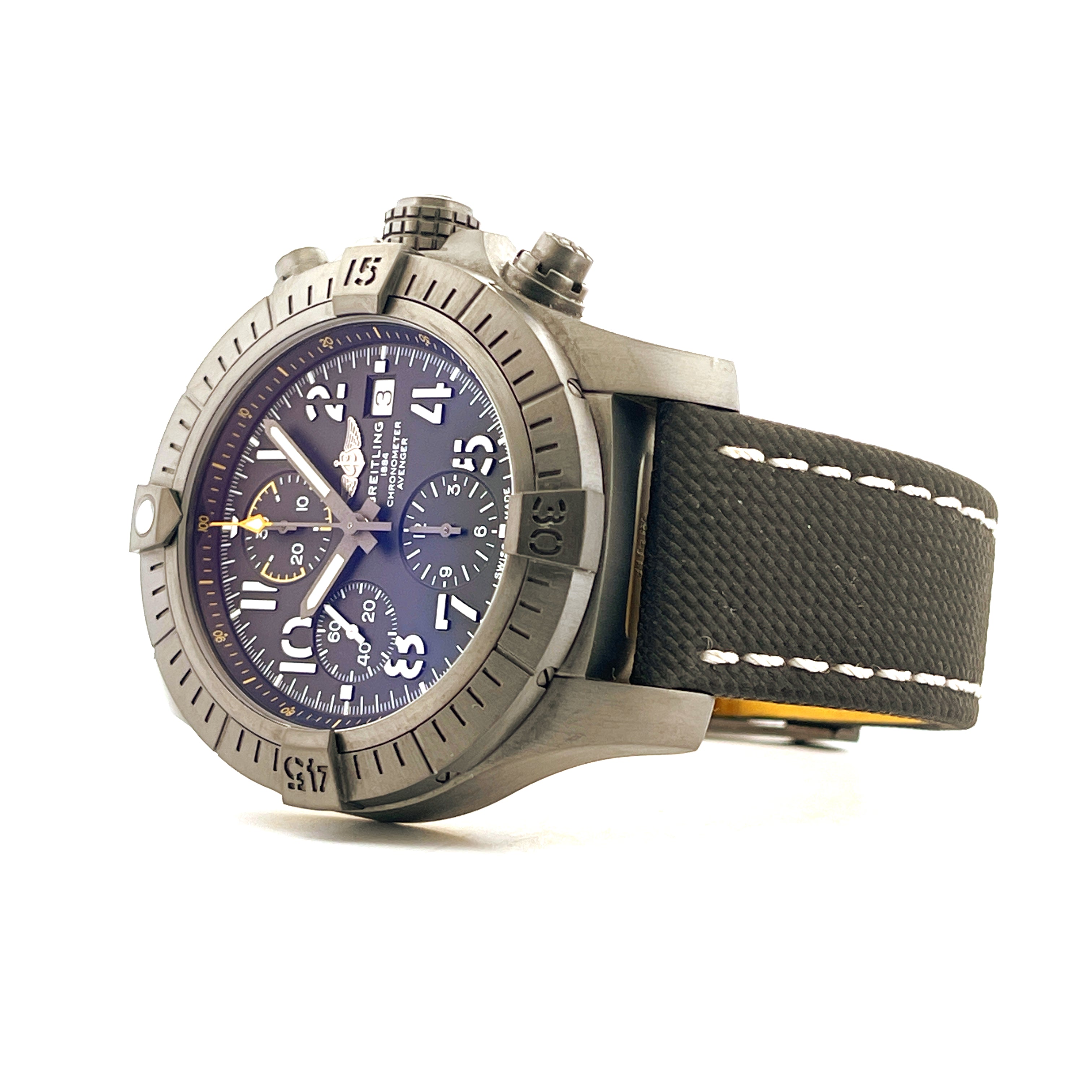 Eine Breitling Avenger Chronograph Night Mission aus Titan DLC mit schwarzem Textilarmband auf weißem Hintergrund