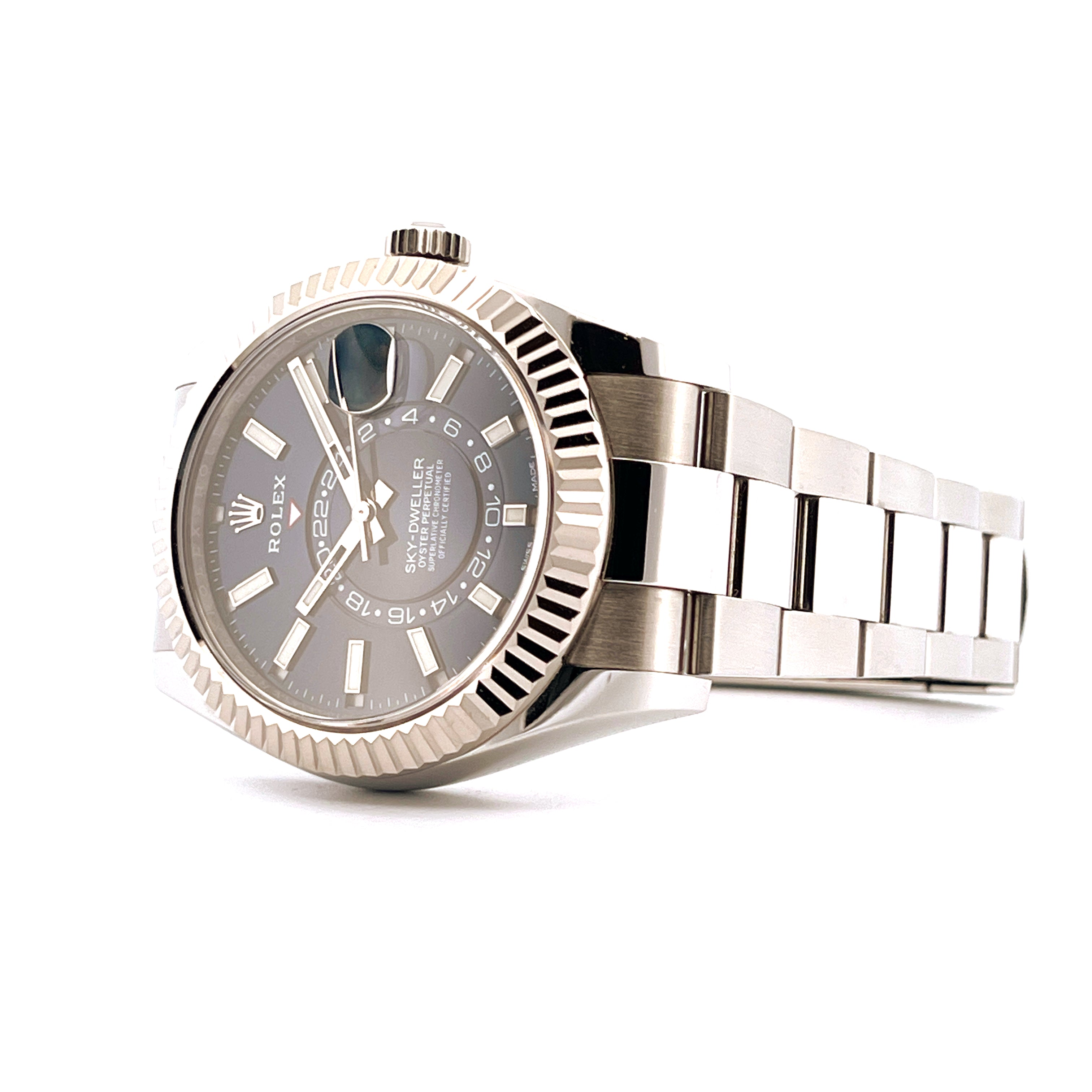 Rolex Sky-Dweller aus Edelstahl mit grauem Zifferblatt und geriffelter Lünette in Nahaufnahme auf weißem Hintergrund