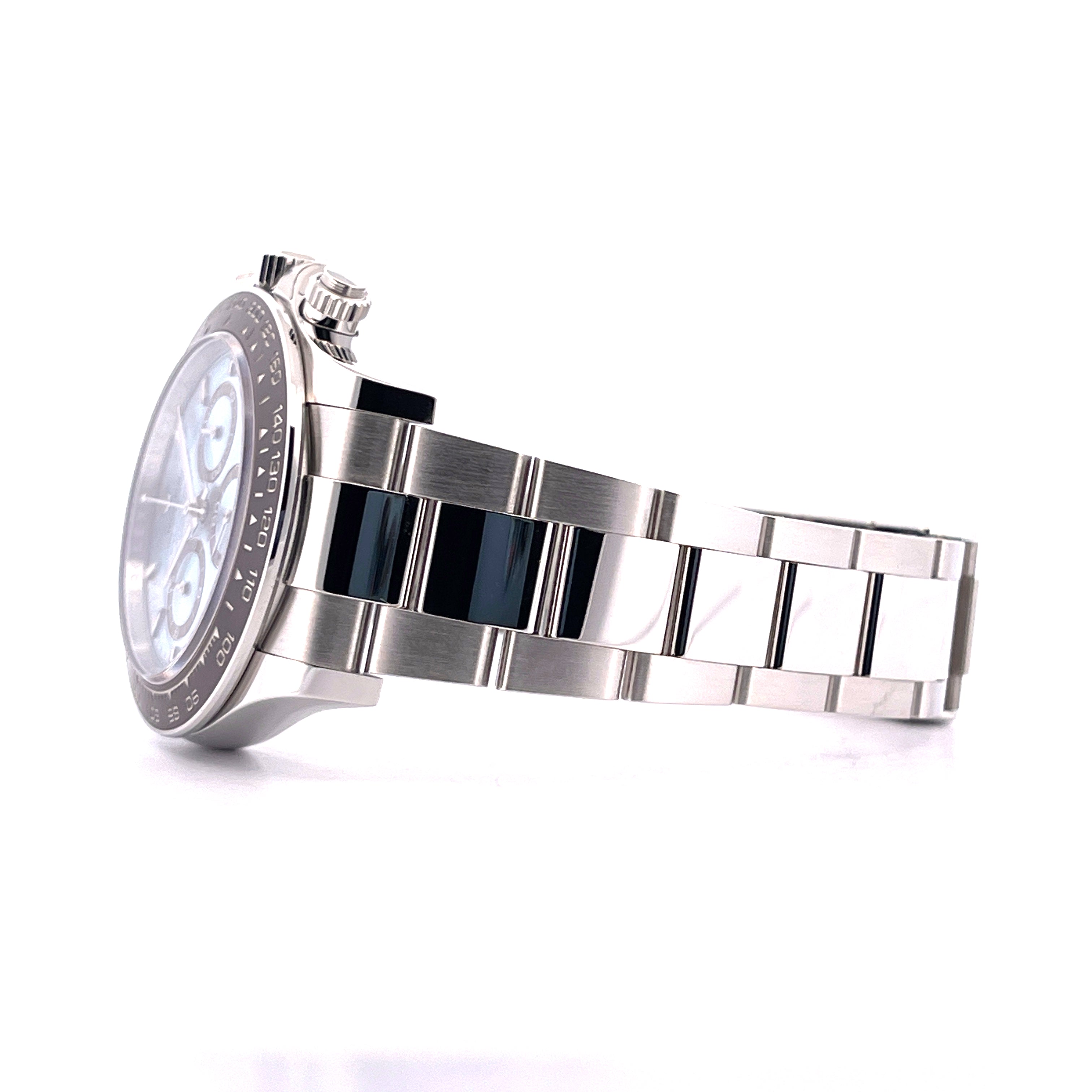 Seitenansicht einer Rolex Daytona Platin Eisblau 126506 mit silbernem und schwarzem Armband auf weißem Hintergrund