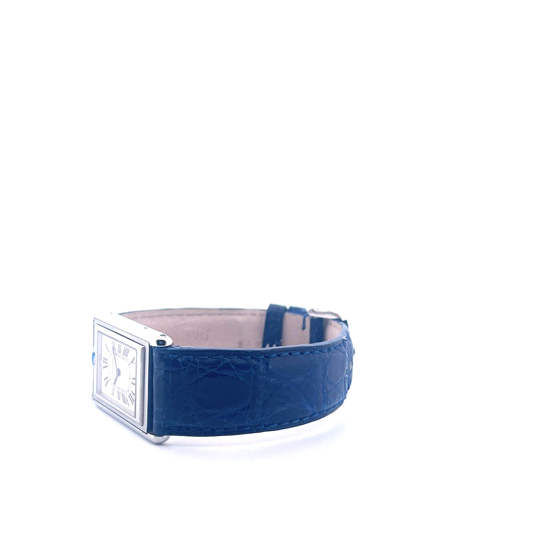 Eine Cartier Tank Basculante mit blauem Kroko-Armband in Seitenansicht auf weißem Hintergrund