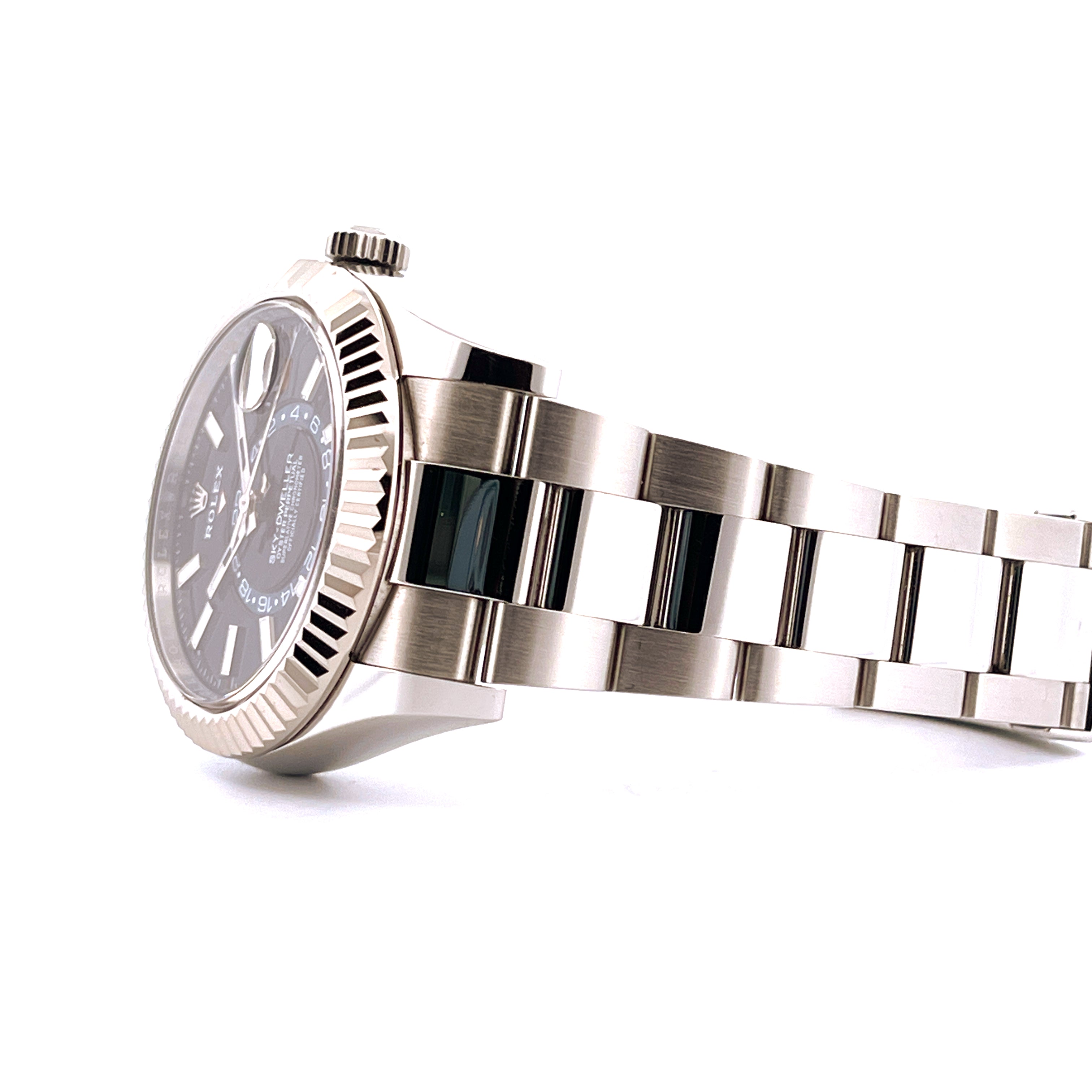 Rolex Sky-Dweller Stahl mit geriffelter Weißgoldlünette und dunkelblauem Zifferblatt Seitenansicht auf weißem Hintergrund