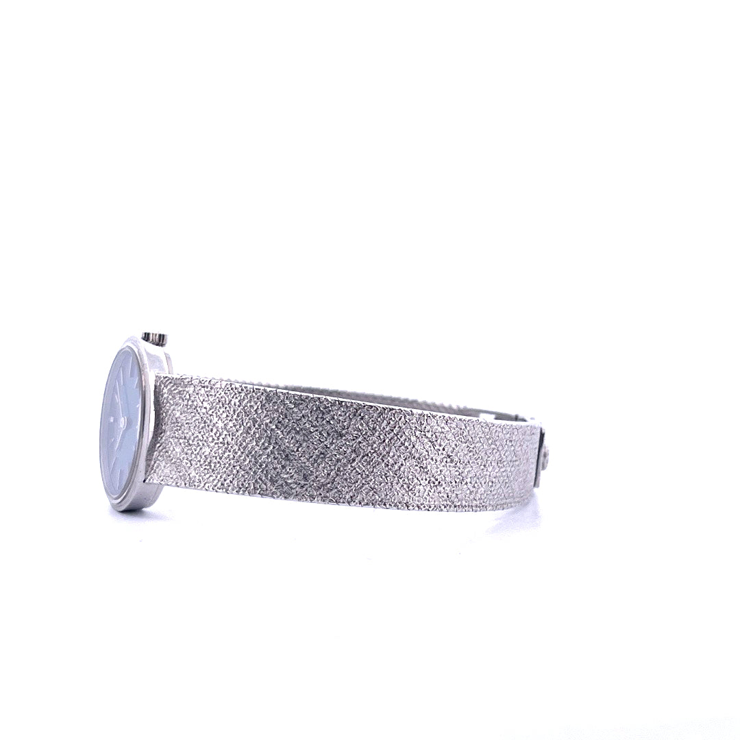 Seitenansicht einer Patek Philippe Ellipse d'Or Weißgolduhr mit strukturiertem Armband auf weißem Hintergrund