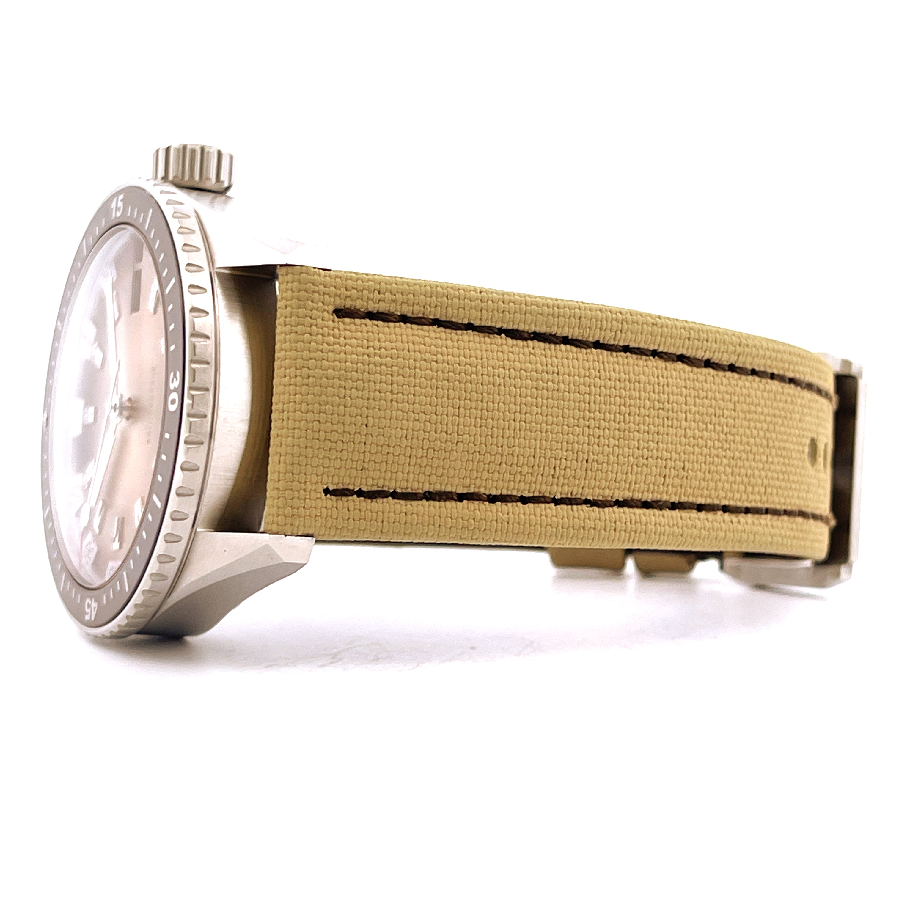 Seitenansicht einer Blancpain Fifty Fathoms mit sandfarbenem Textilarmband auf weißem Hintergrund