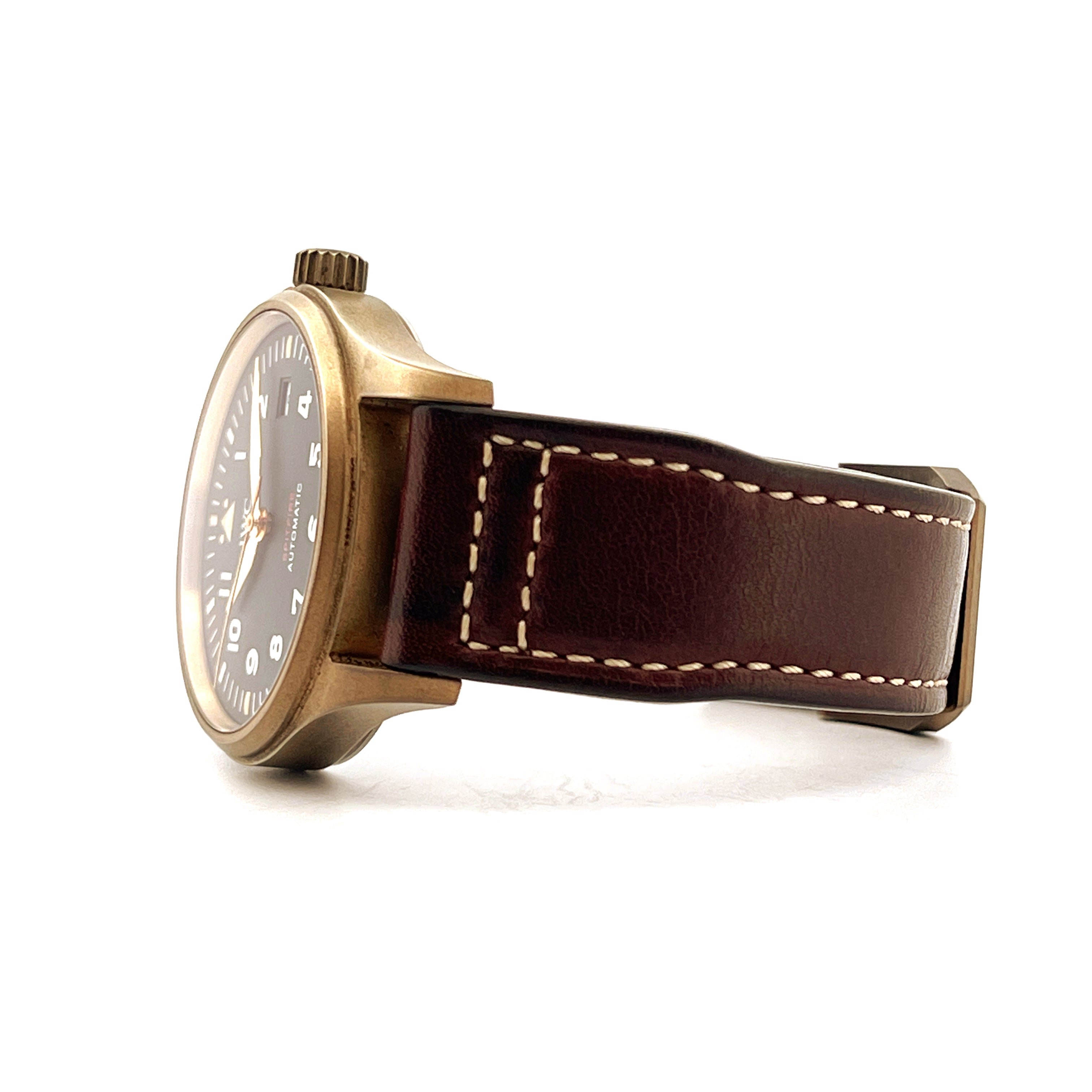 Seitenansicht einer IWC Spitfire Automatic Green Bronze Uhr mit braunem Lederarmband auf weißem Hintergrund