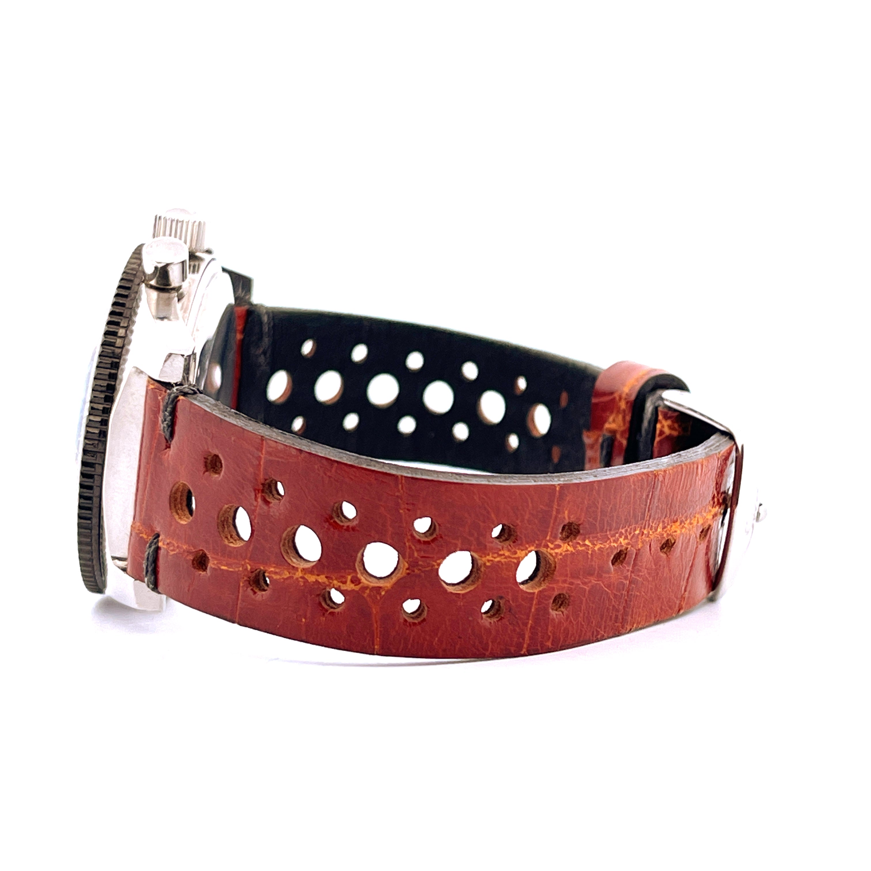 Sinn Vintage Chronograph 102A im Profil mit braunem Lochlederarmband und silbernem Gehäuse auf weißem Hintergrund