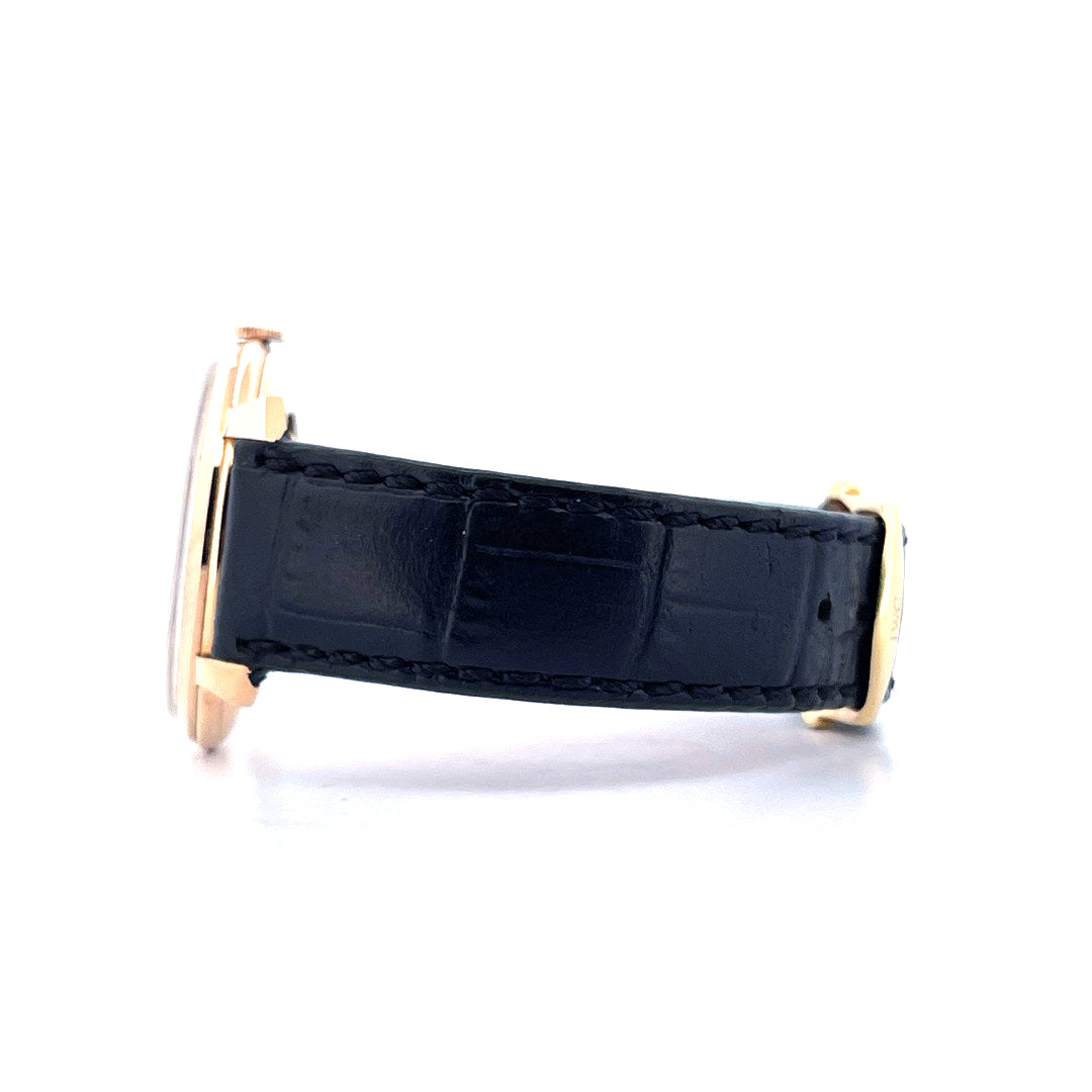 Seitenansicht einer goldenen IWC mit schwarzem Kroko-Lederarmband auf weißem Hintergrund