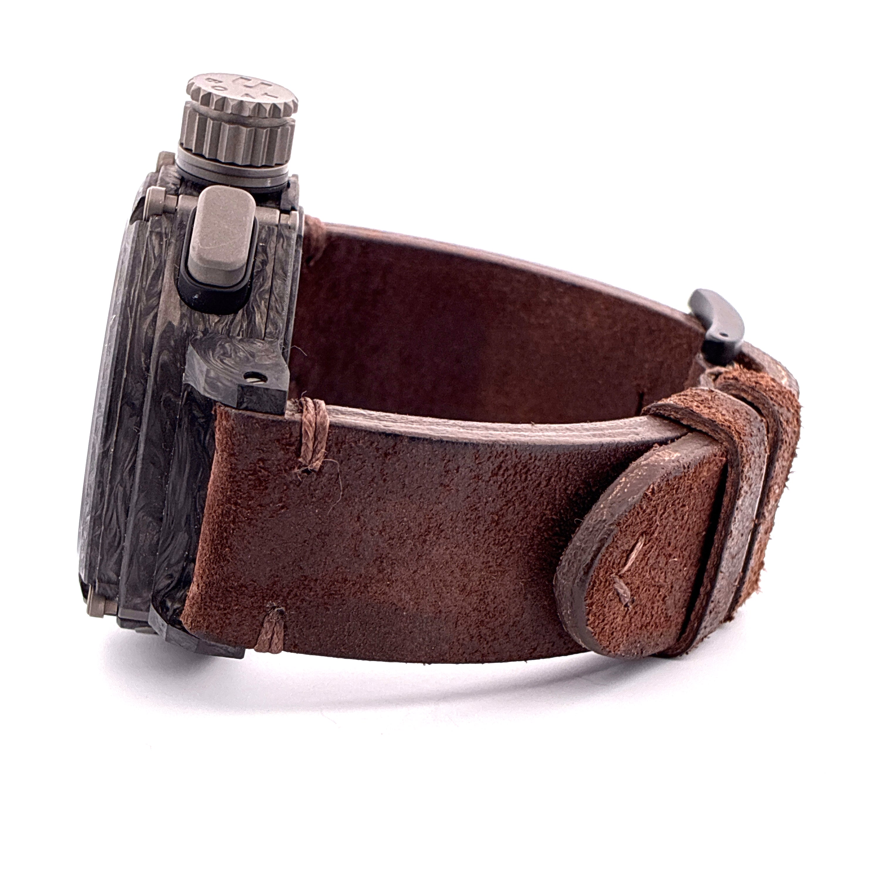 Seitenansicht einer U-BOAT Chimera Uhr aus Carbon mit braunem Lederarmband vor weißem Hintergrund