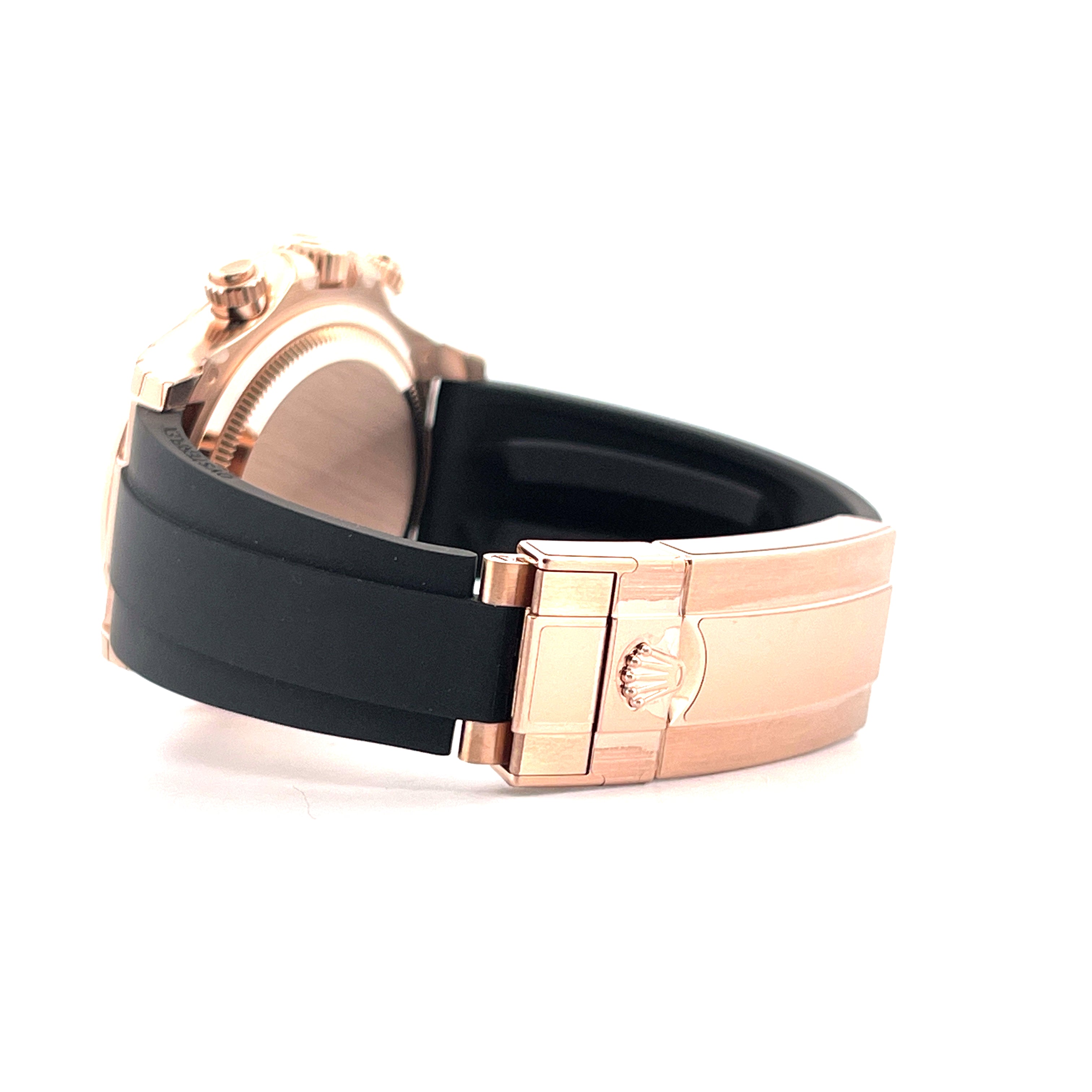 Seitenansicht einer Rolex Cosmograph Daytona aus Roségold mit schwarzem Kautschukarmband und Schließe