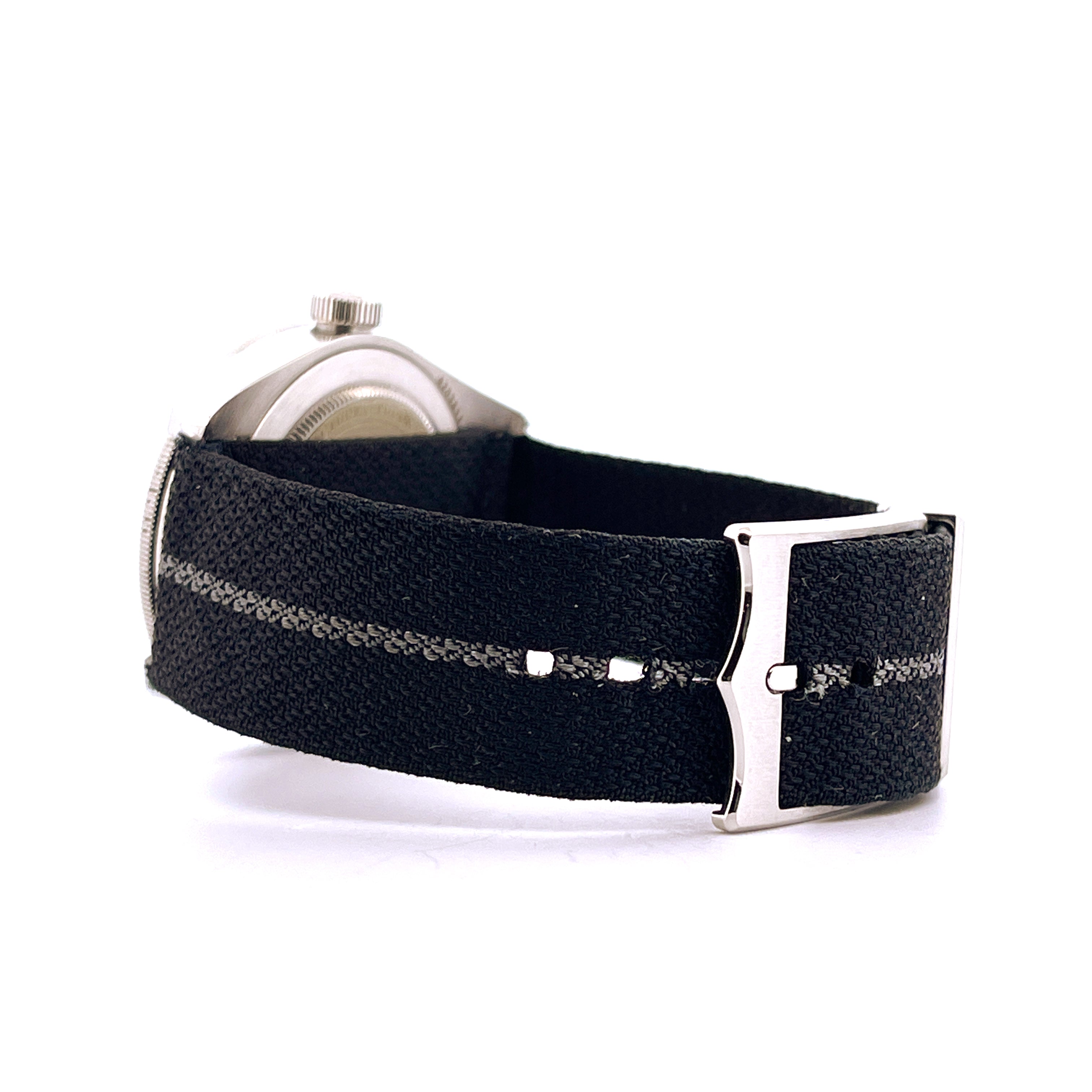 Seitenansicht einer Tudor Black Bay Fifty-Eight Navy Blue (2022) mit schwarzem Textilarmband und Stahlschließe auf weißem…
