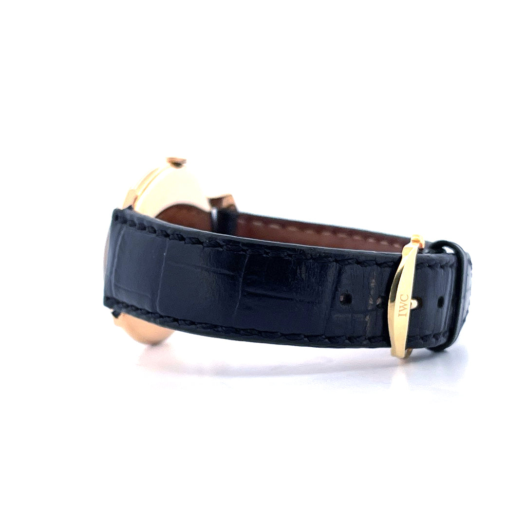 IWC Shark Fin Uhr, goldfarbene Schließe mit IWC-Logo auf schwarzem Lederarmband, Seitenansicht auf weißem Hintergrund
