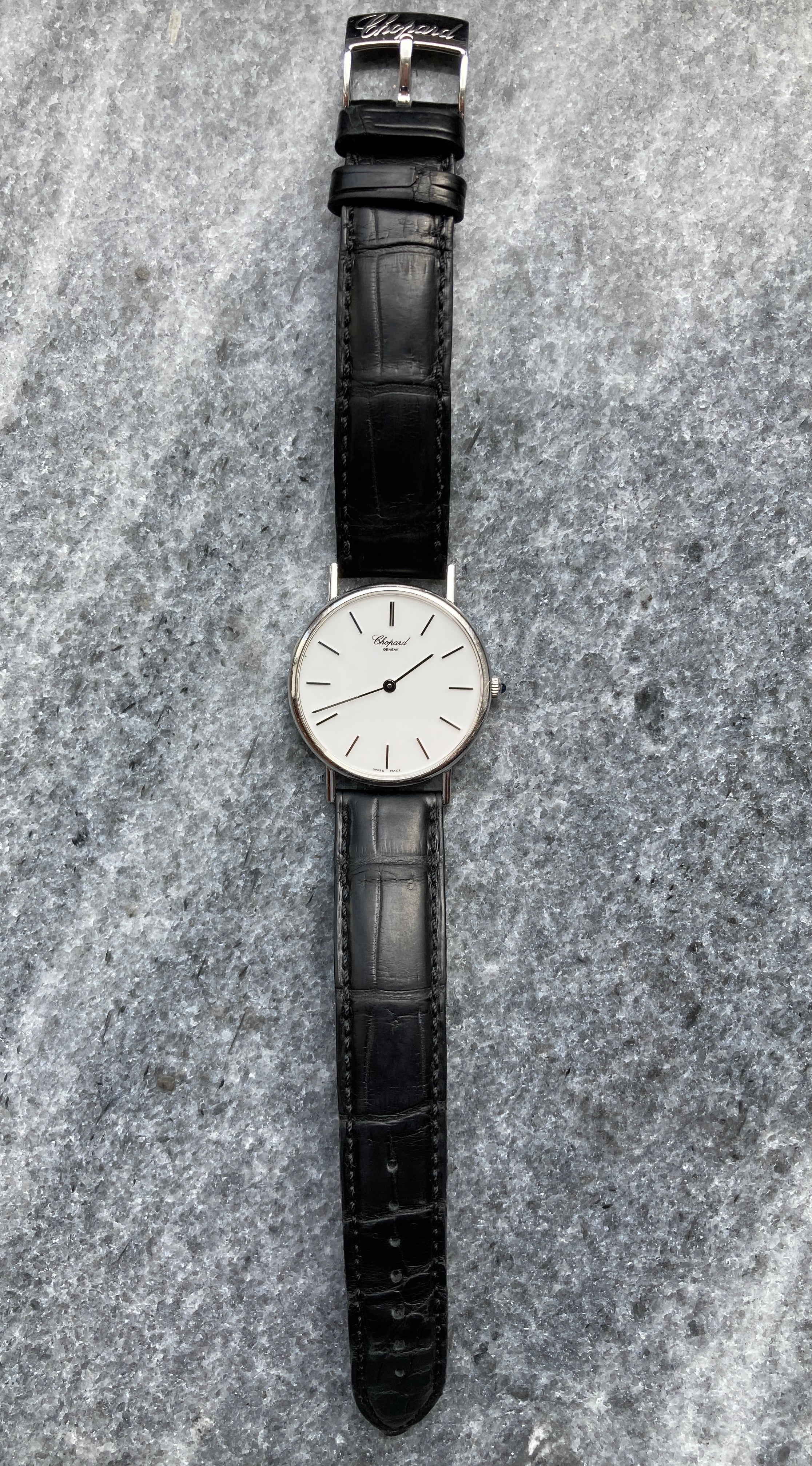 Chopard Ultra Thin Classic 1996 aus Weißgold mit schwarzem Lederarmband auf grauem Steinuntergrund