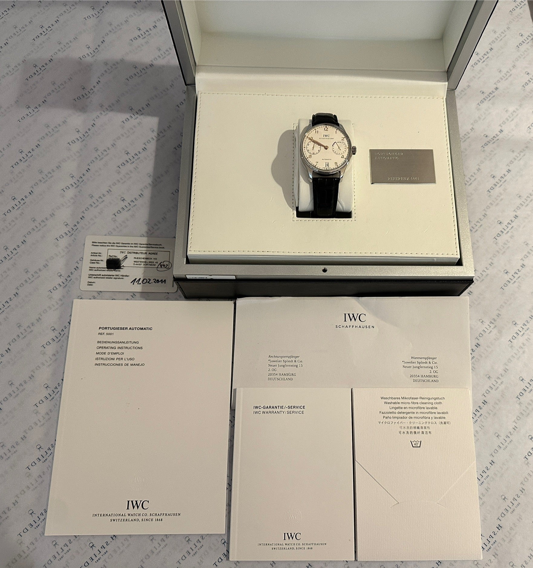 IWC Portuguese Automatic 7 Tage aus Edelstahl mit Lederband im geöffneten IWC Karton mit Papieren
