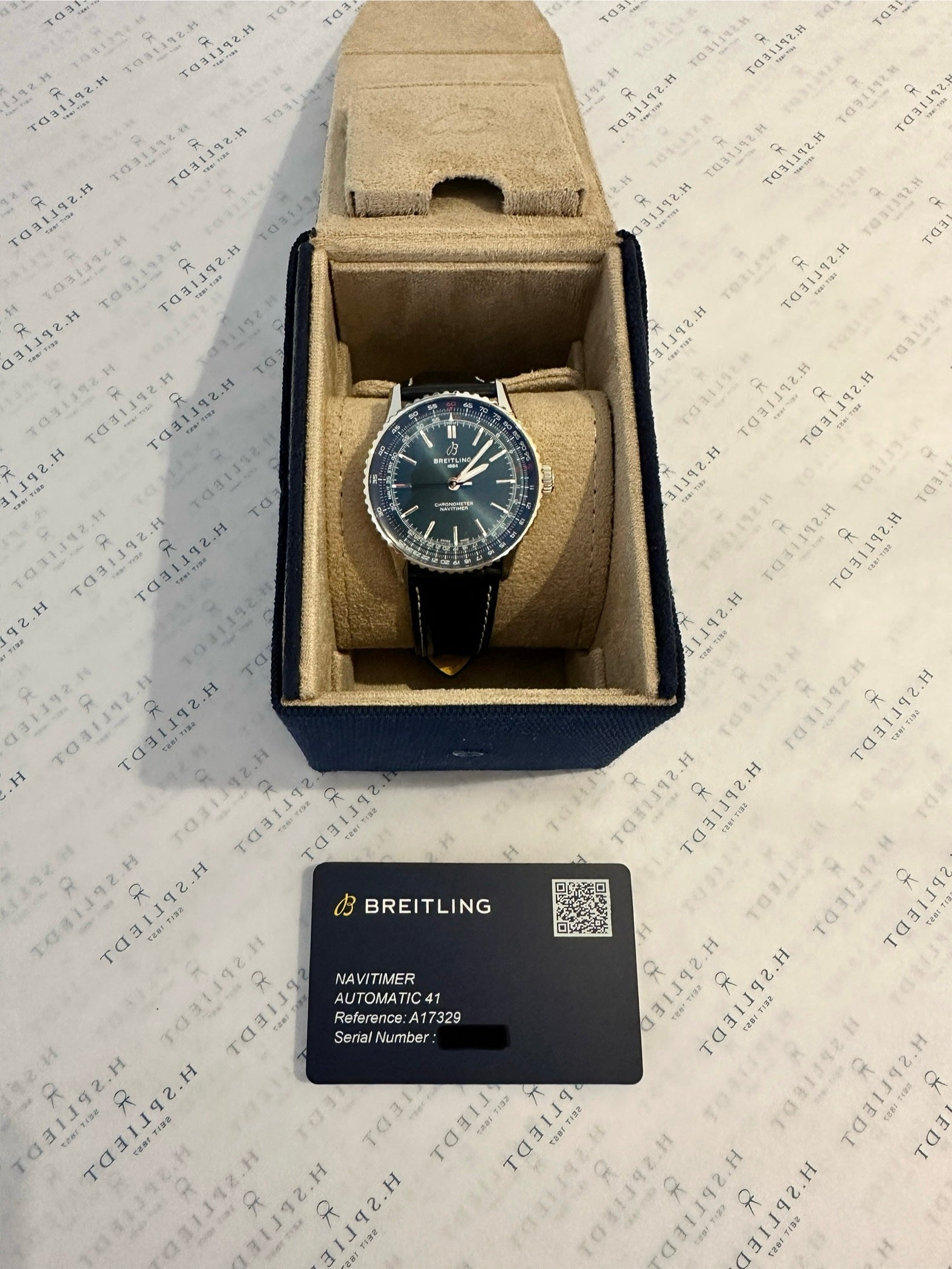 Breitling Navitimer Automatic 41 im geöffneten Karton auf weißem Untergrund mit Präsentationskarte