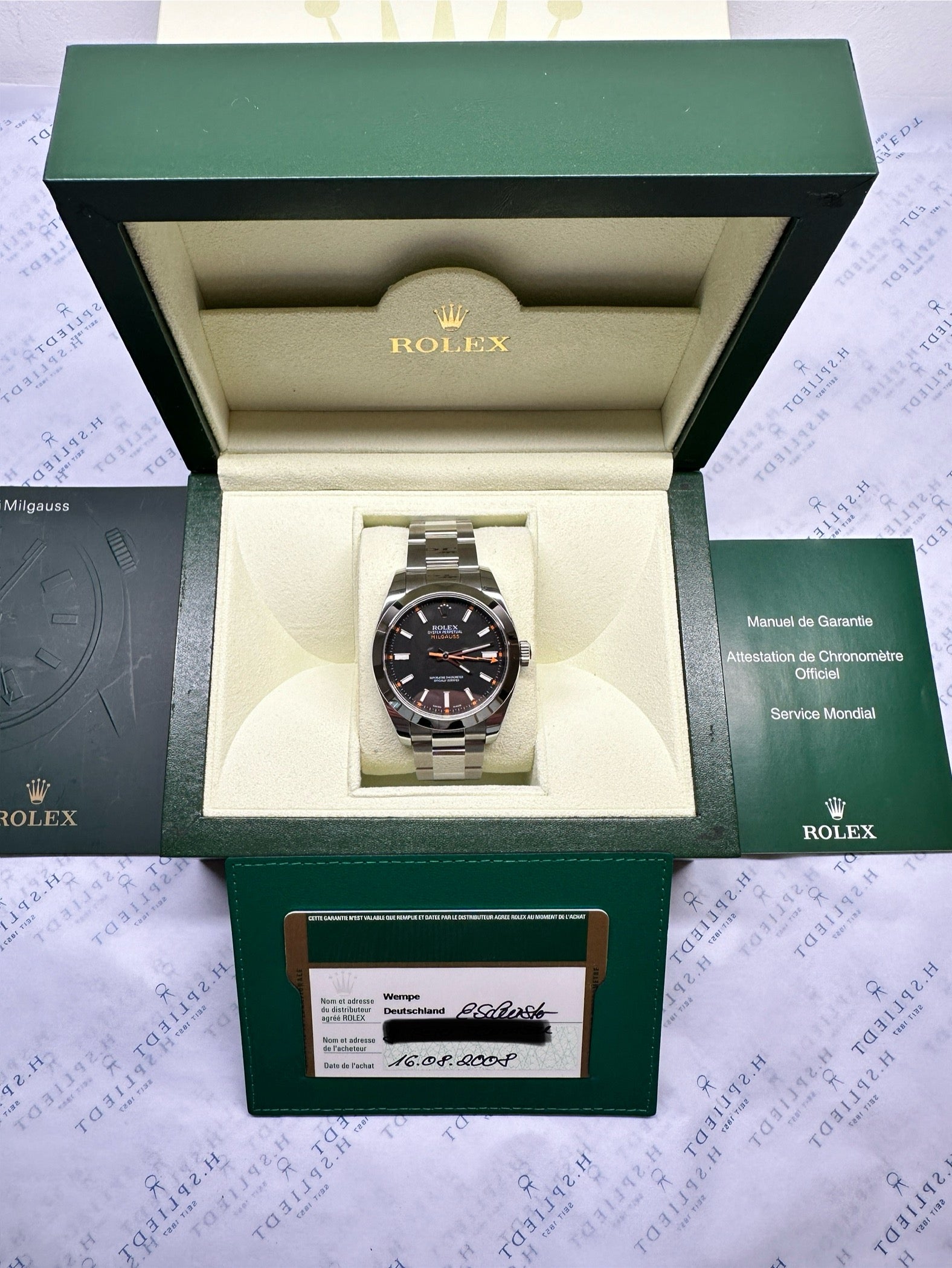 Rolex Milgauss 116400 im geöffneten grünen Rolex-Karton mit Garantiekarte und Anleitung