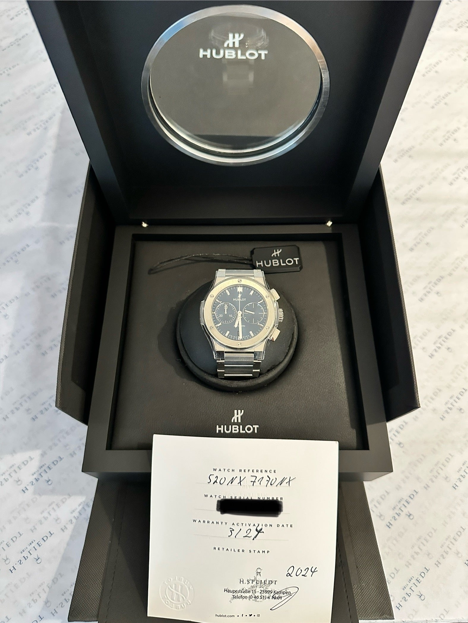 Hublot Classic Fusion Chronograph aus Titan im geöffneten Karton mit Papieren und Stempel