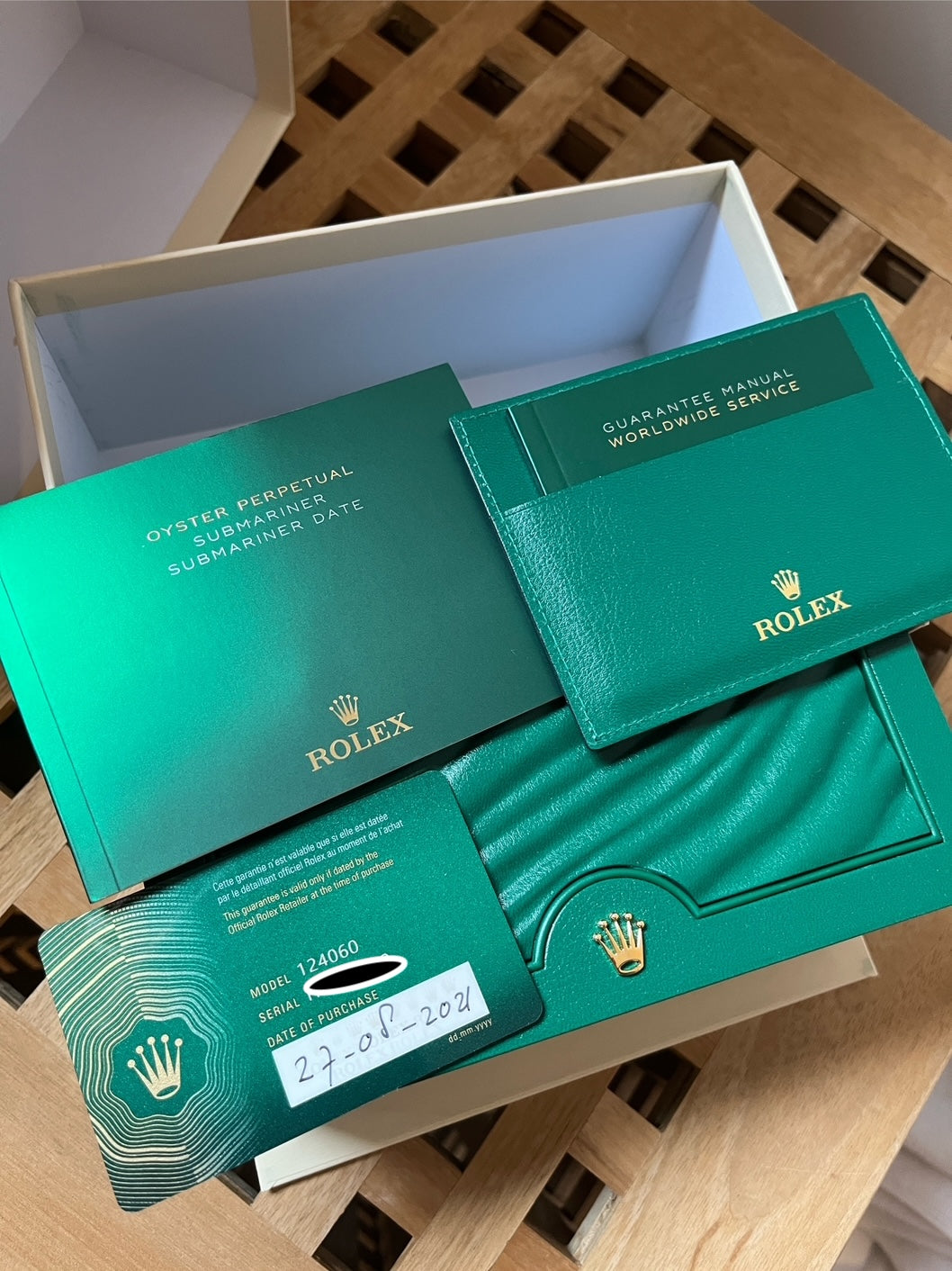 Rolex Submariner No Date 2021 im geöffneten grünen Karton mit Garantiekarte im Detail