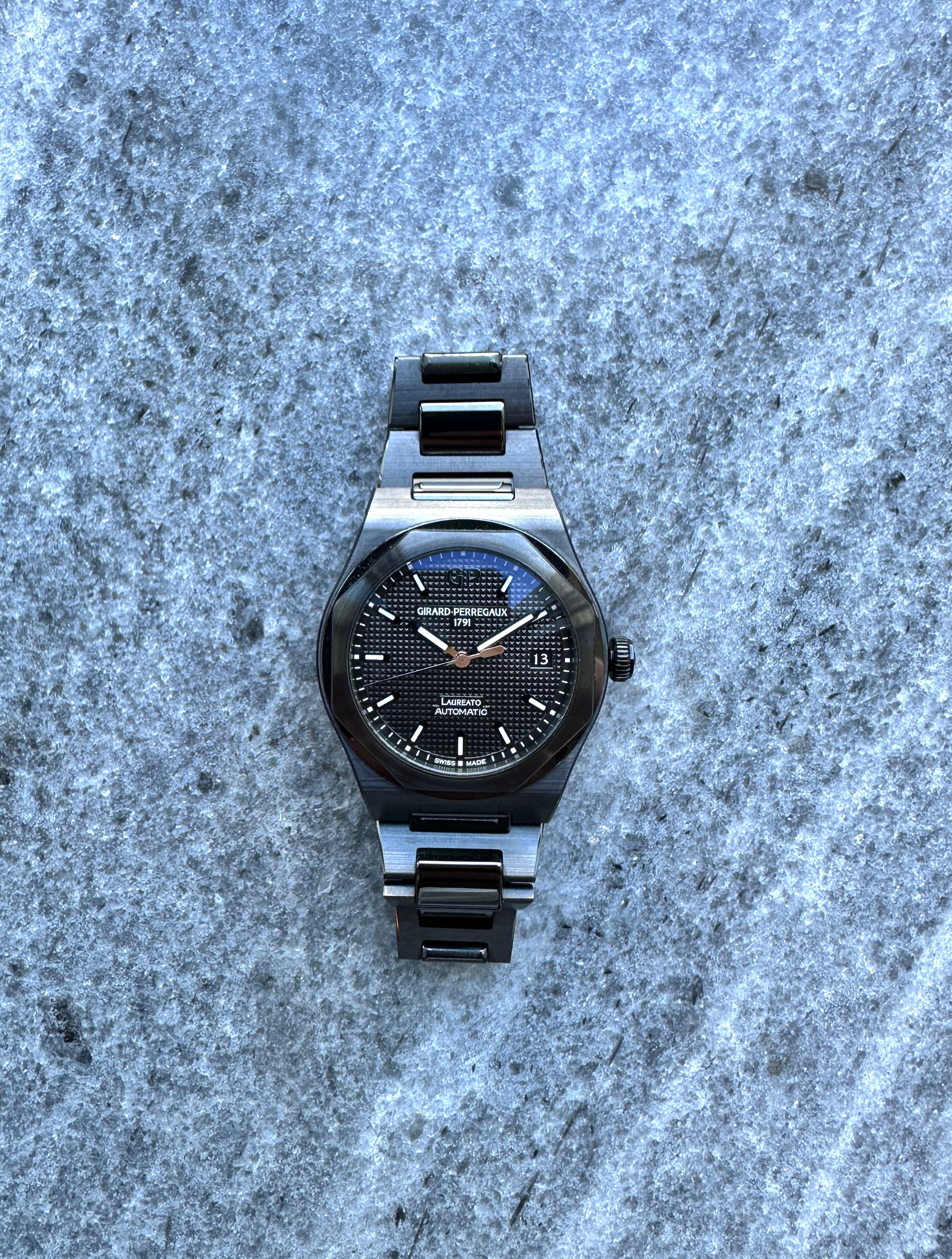 Girard Perregaux Laureato 38 Ceramic von 2021 mit schwarzem Zifferblatt auf steinigem Untergrund