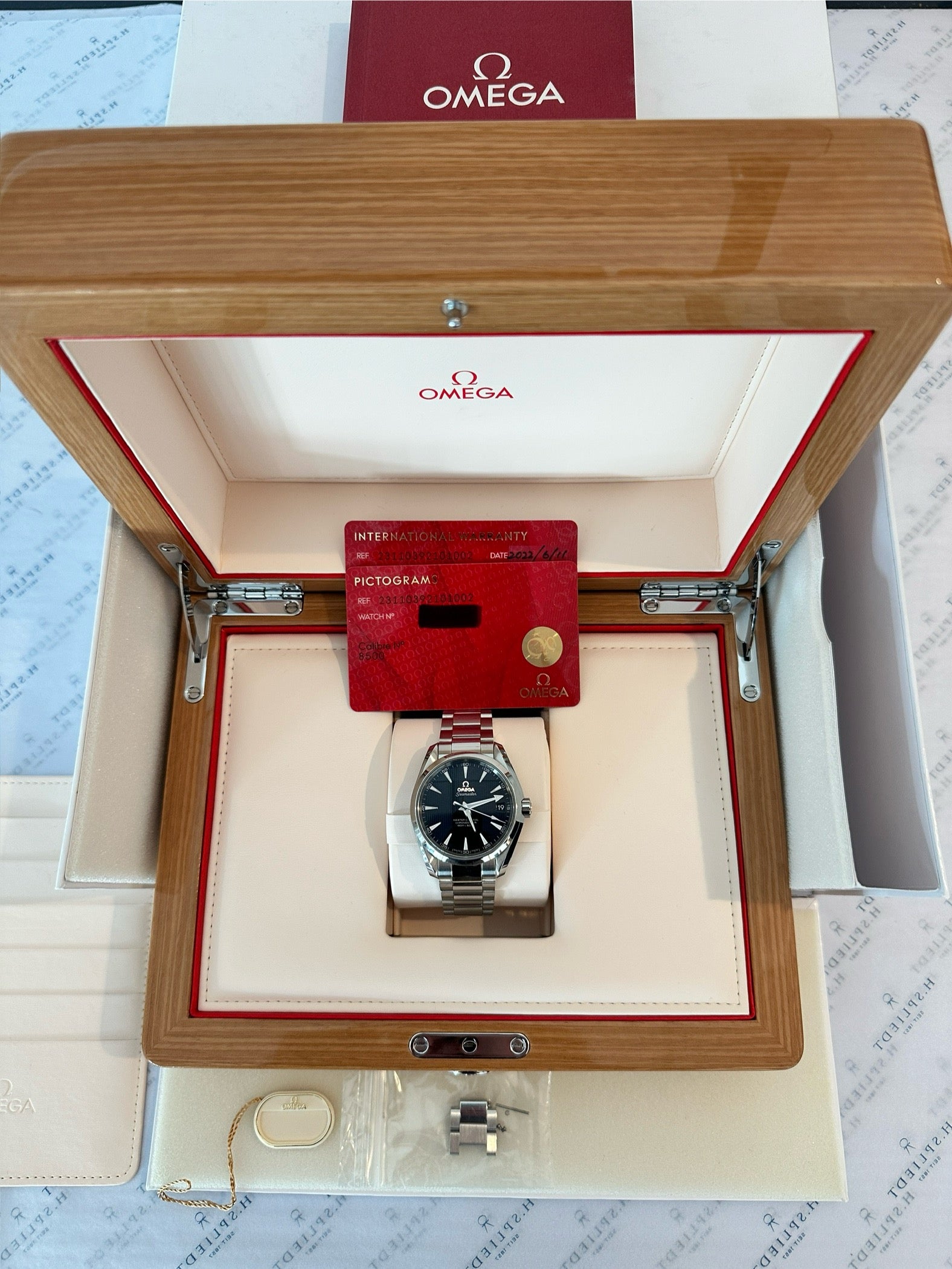 Omega Seamaster Aqua Terra 38,5 im aufgeklappten Holzgehäuse mit Garantiekarte