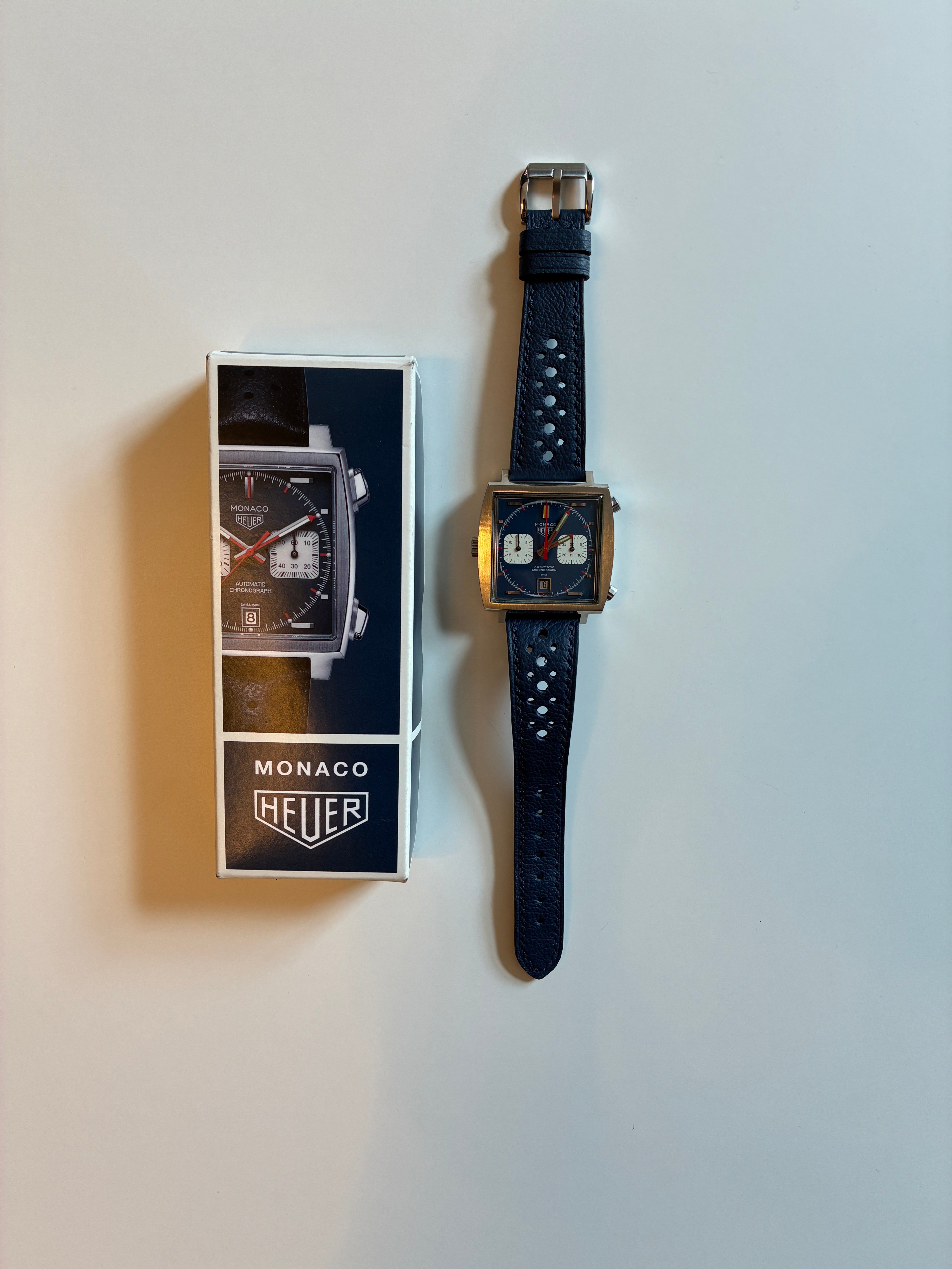 Tag Heuer Monaco Calibre 11 mit blauem Zifferblatt und Lederarmband auf weißem Hintergrund