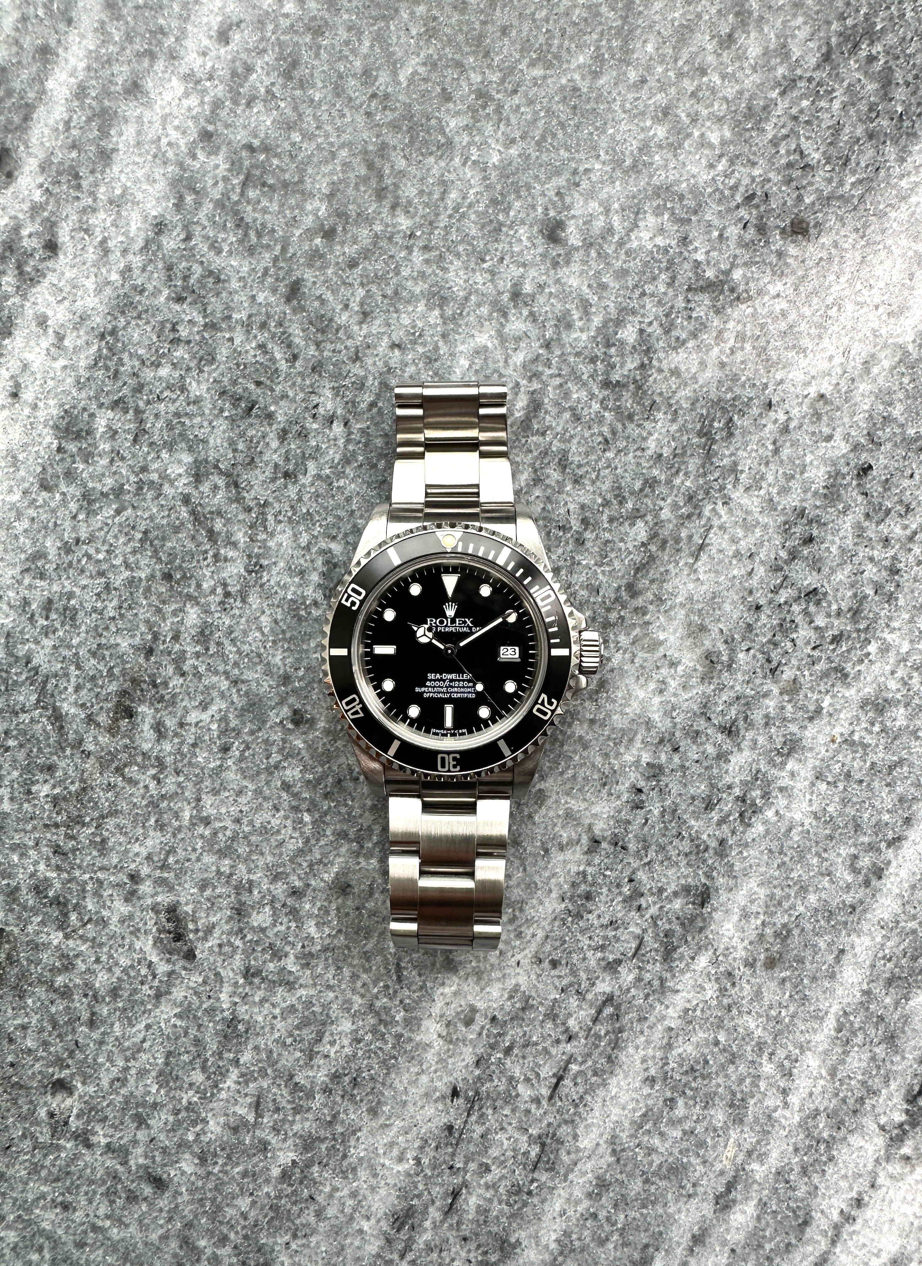 Rolex Sea-Dweller Ref. 16600 aus Stahl, Frontansicht, auf grauem Steinboden