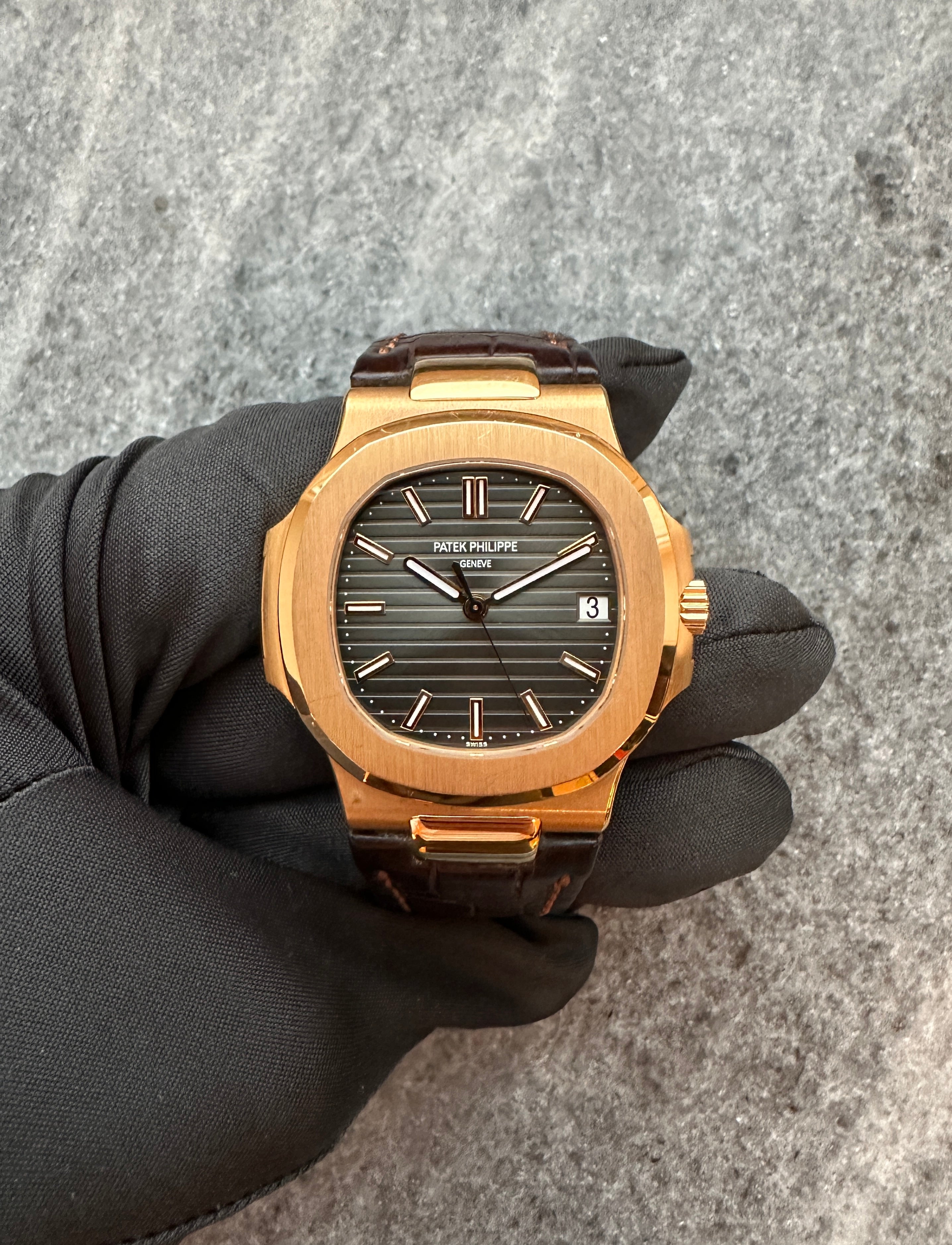 Patek Philippe Nautilus 5711R-001 aus Roségold mit dunkelbraunem Lederarmband auf grauem Grund