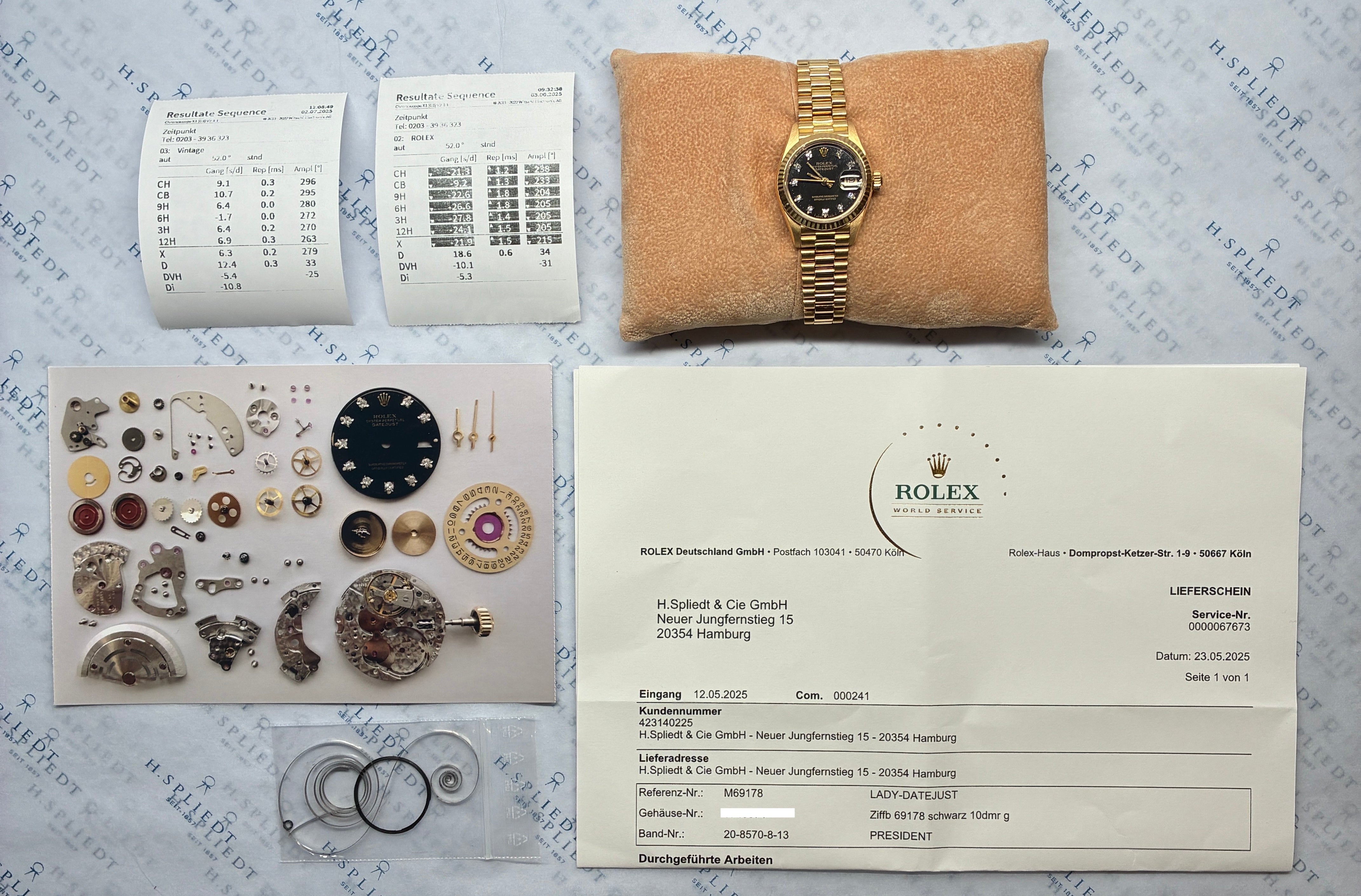Rolex Lady-Datejust gold mit schwarzem Zifferblatt, 10 Diamanten-Indizes und Datumslupe vor zerlegten Uhrwerksteilen und Servicepapieren