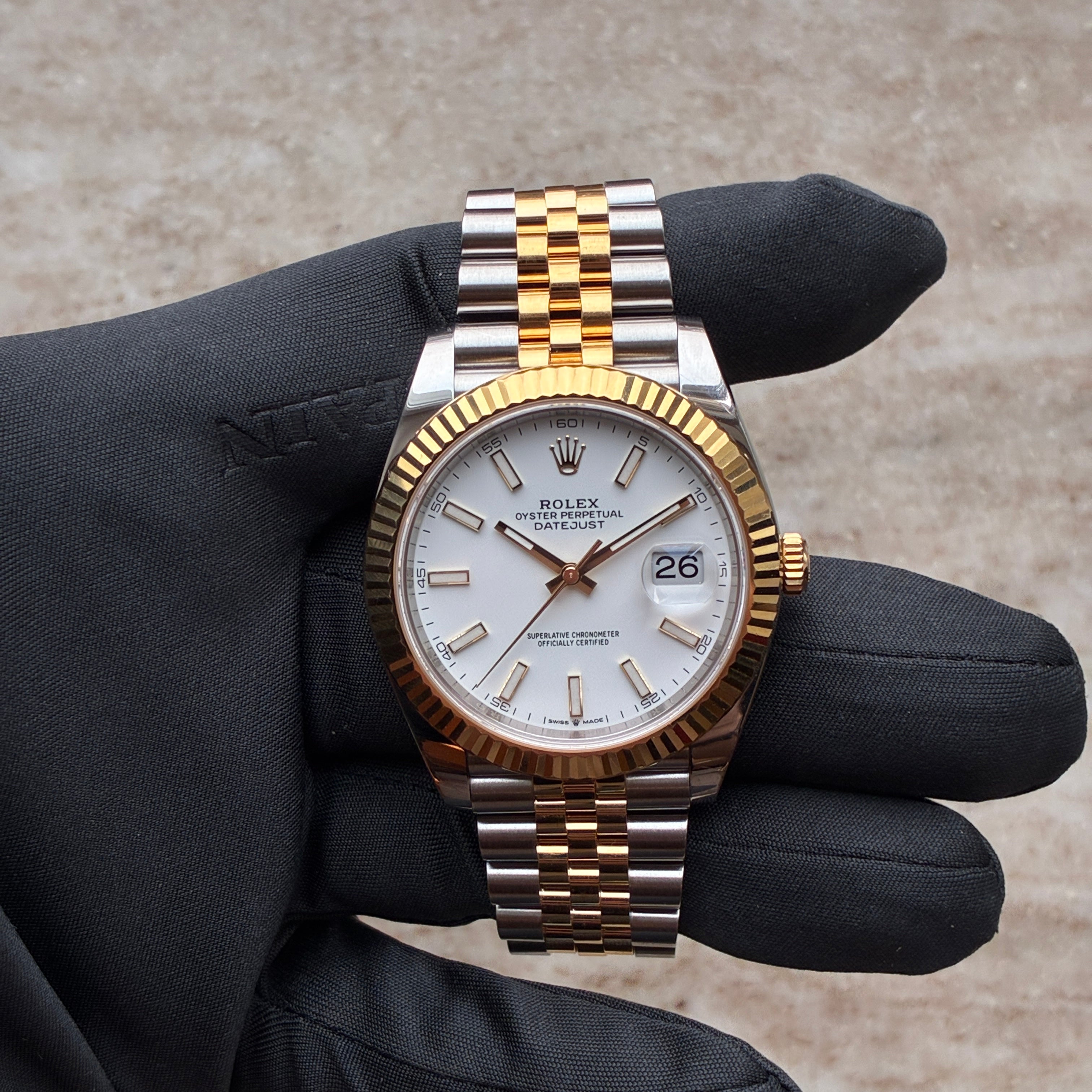 Rolex Datejust 41 Bicolor von oben gezeigt, mit goldener Lünette, zwei Zeigern, einem Datumsfenster und weißem Zifferblatt