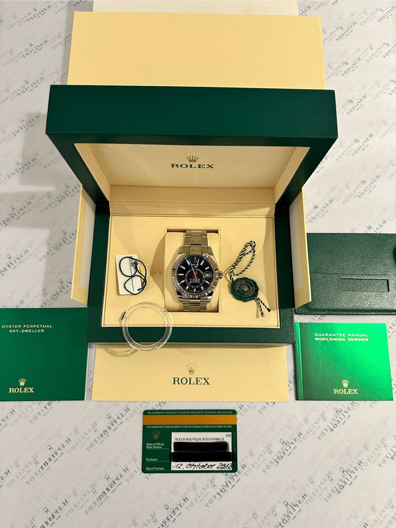 Rolex Sky-Dweller Automatik mit blauem Zifferblatt in geöffneter Box mit Garantiekarte