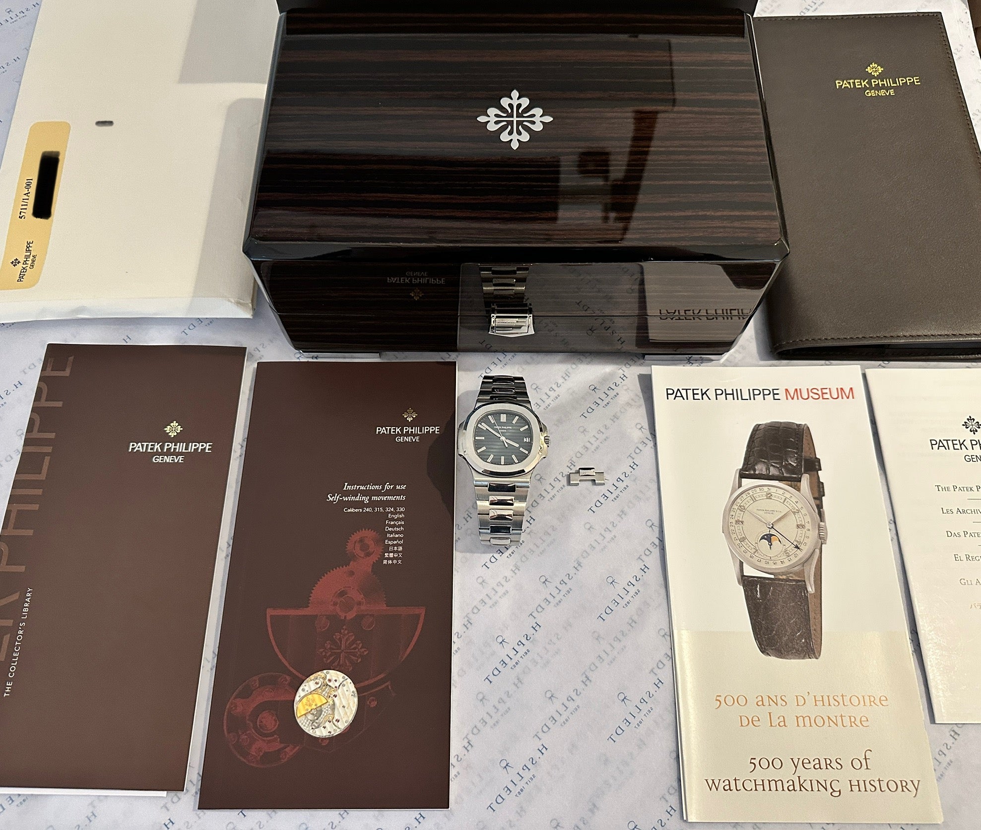 Patek Philippe Nautilus 5711/1A-001 Stahl mit Box und Papieren auf dunkelbraunem Hintergrund